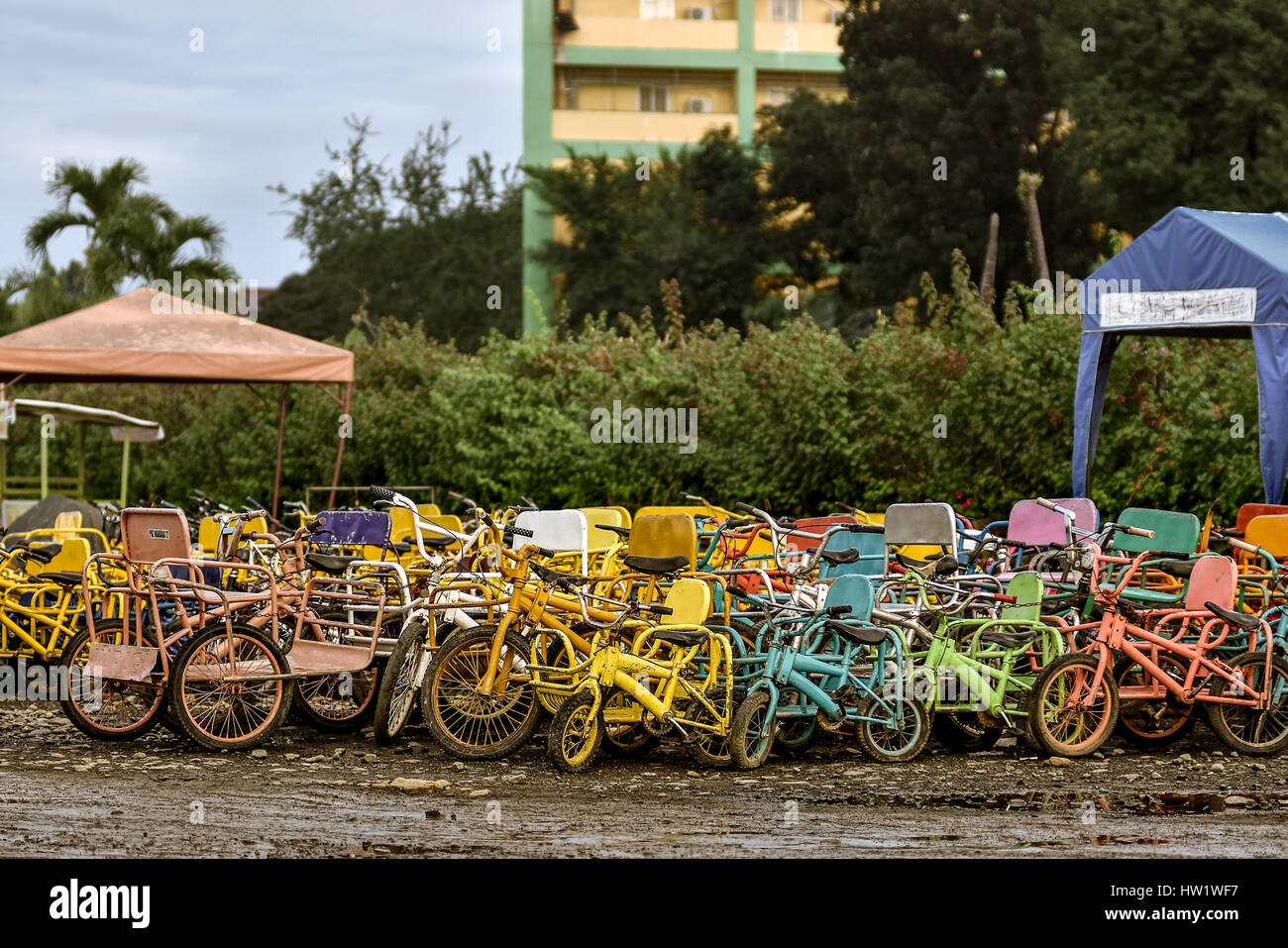 Una selezione di bambini, Biciclette Tricicli e sidecar per noleggio serale presso il lungomare. Foto Stock