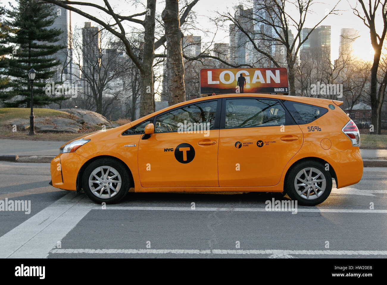 Una vettura ibrida yellow cab è fermo su un semaforo di Central Park. Foto Stock