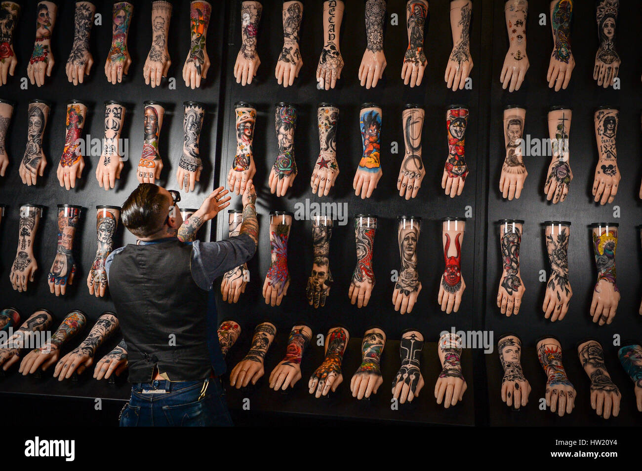 Curatrice della mostra, Dr Matt Lodder, mette la rifinitura di un centinaio di bracci di silicone in mostra presso il Museo Nazionale Marittimo in Colchester, parte della mostra tatuaggio: British Arte del tatuaggio ha rivelato. Foto Stock