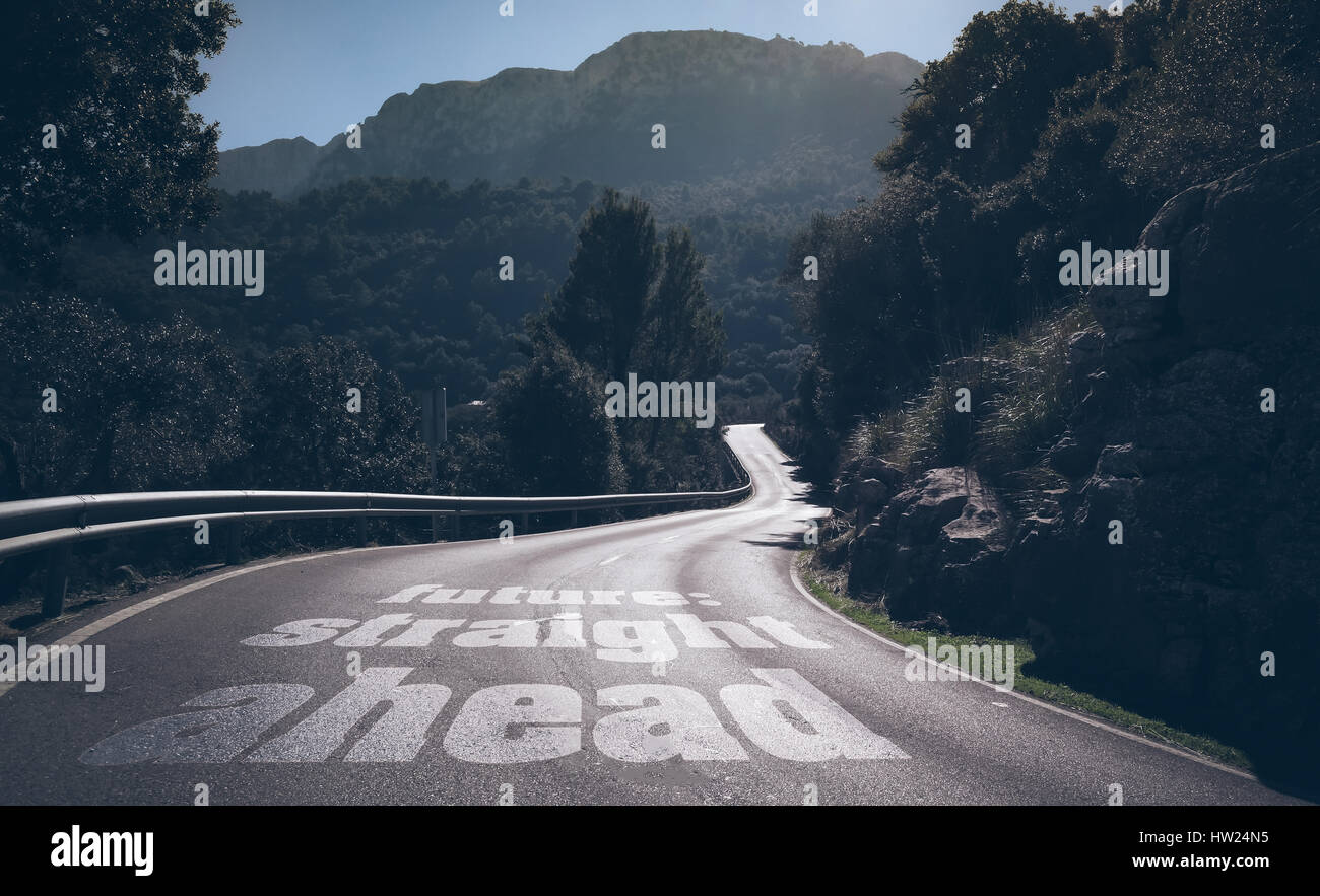 Lunga strada deserta attraverso le montagne con parole futuro dritto scritto su asfalto Foto Stock