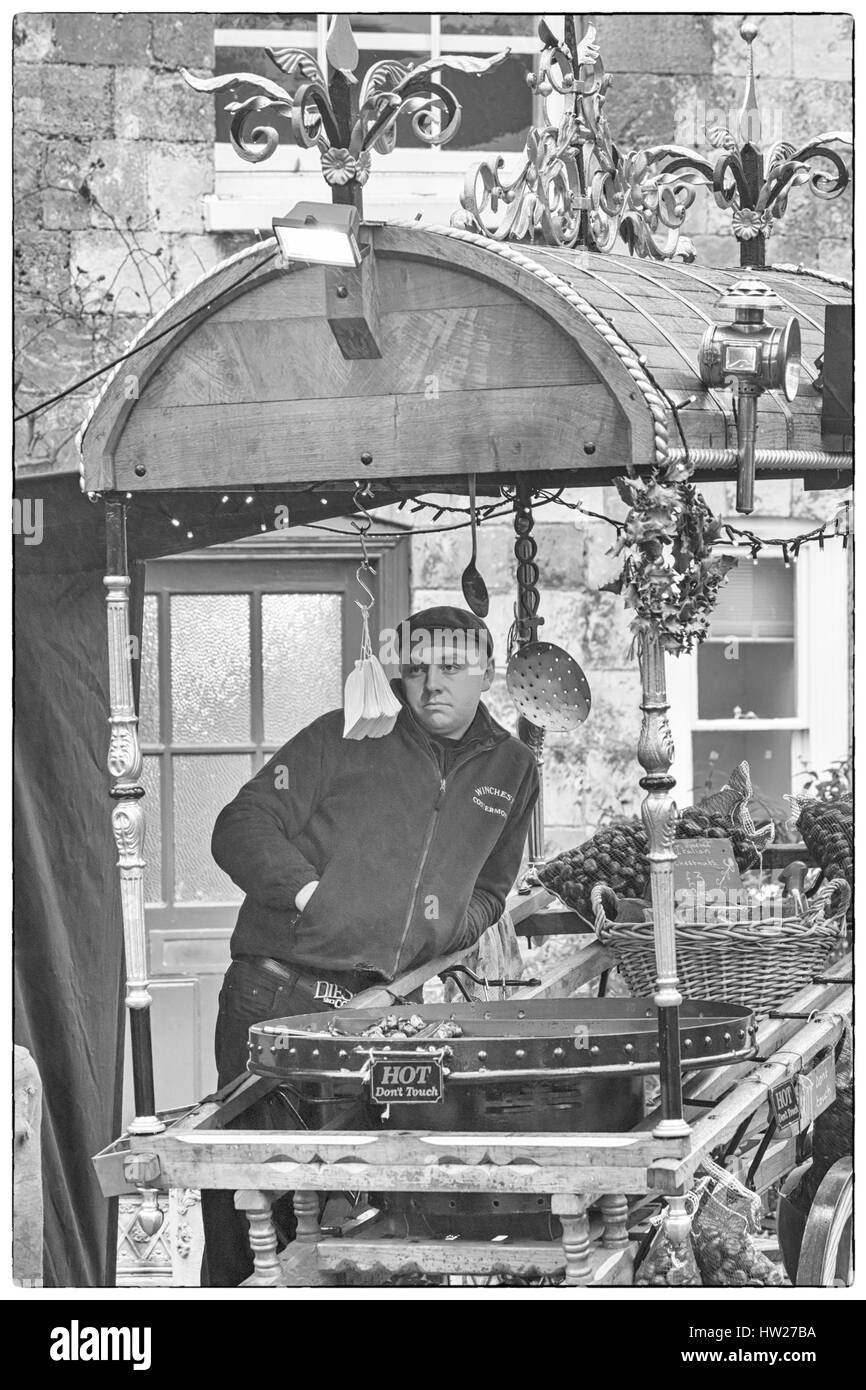 Winchester Mercatini di Natale - Stallo operatore sul carrello costermonger vendono hot castagne arrostite a Winchester Il Mercatino di Natale a dicembre Foto Stock