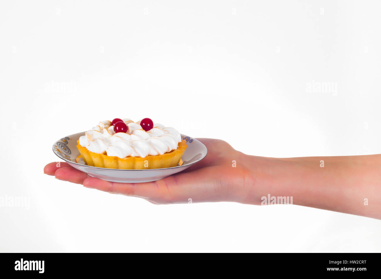 Womans mano azienda piccolo dessert torta sul delicato piastra set Foto Stock