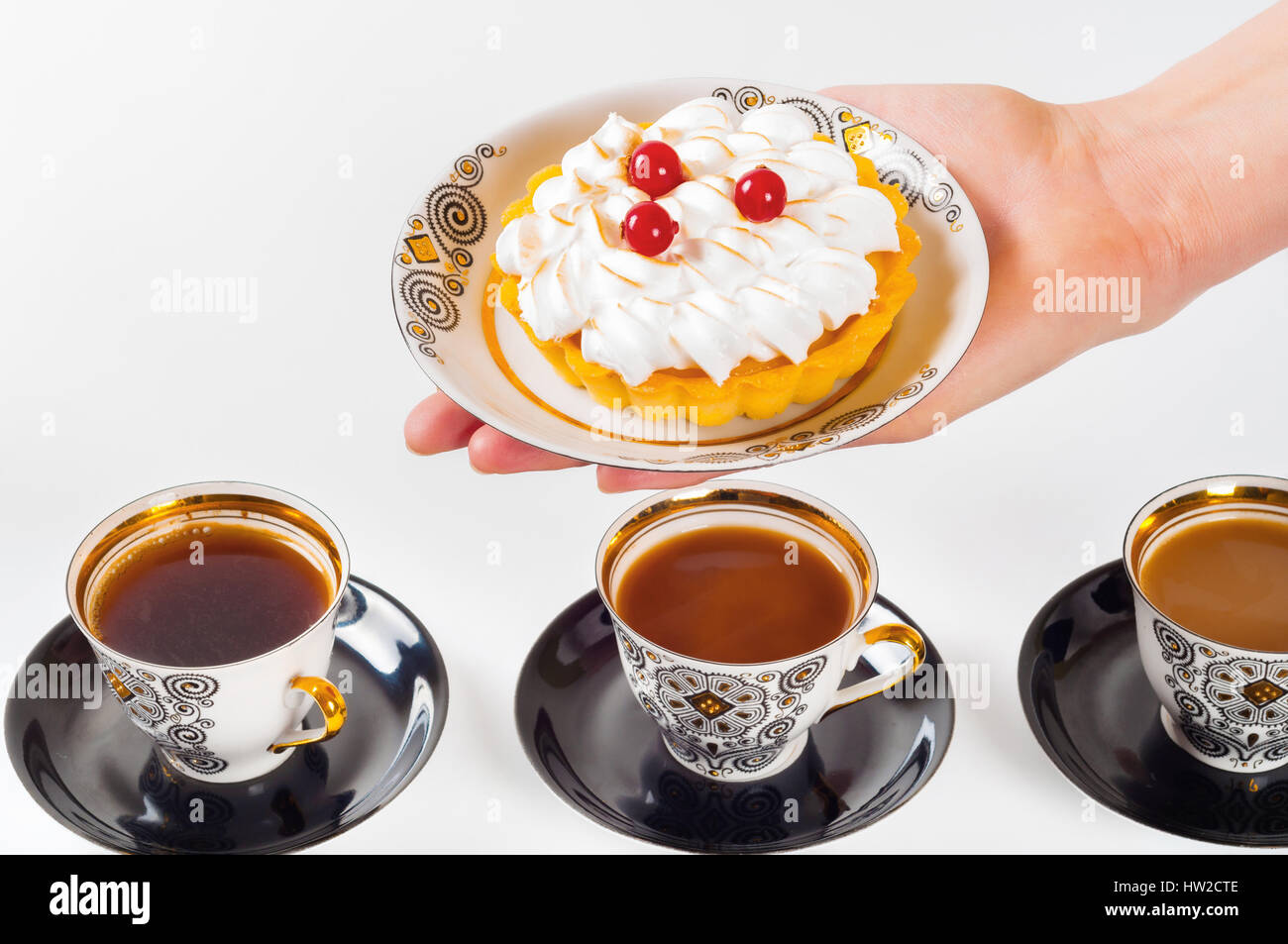 Donna di mano azienda piccola torta sul bel set piastra Foto Stock