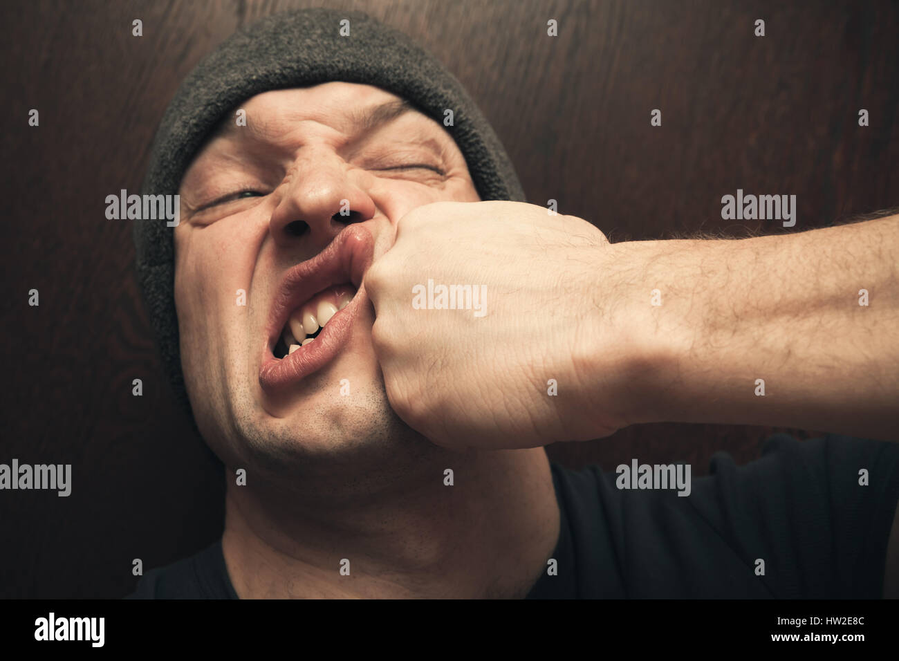 Forte pugno la punzonatura il volto del giovane arrabbiato uomo caucasico Foto Stock