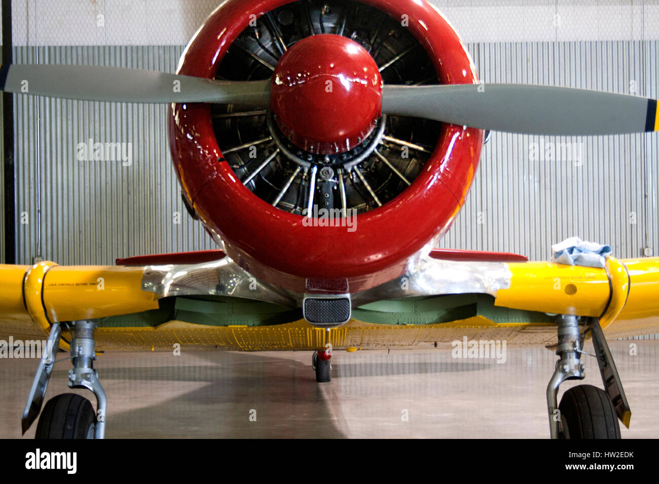 Elica di una piccola annata di rosso e di giallo aeroplano in un hangar. Foto Stock