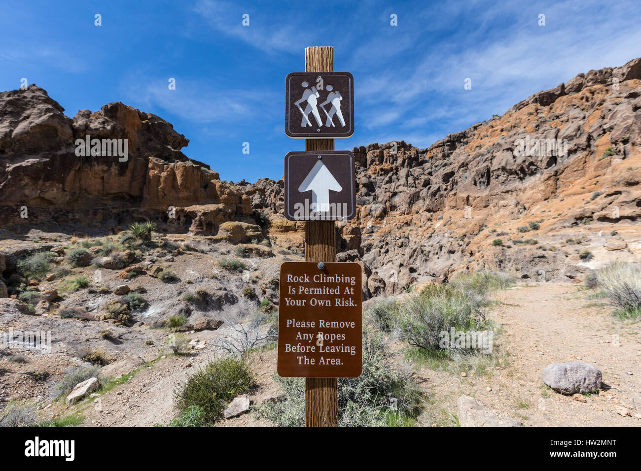 Il sentiero e le arrampicate su roccia segno presso il Mojave National Preserve nella California Meridionale. Foto Stock