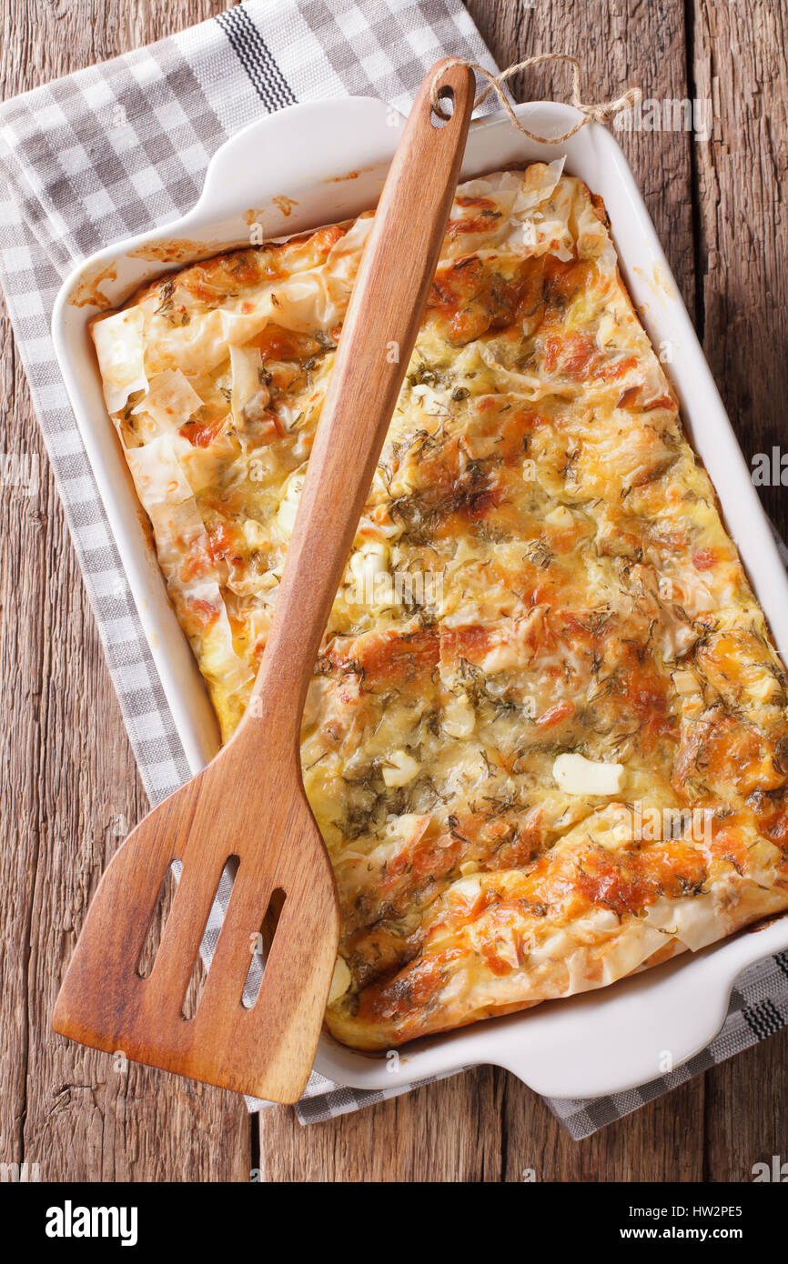 Il cibo dei Balcani: serbo Gibanica torta al formaggio, uova e verdi di close-up in una teglia. Vista verticale da sopra Foto Stock