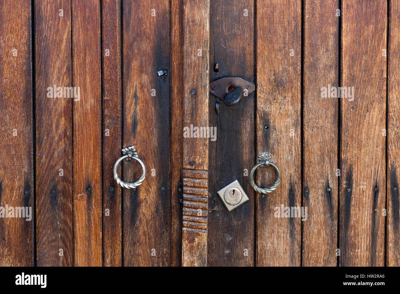Legno marrone porta di tavole con impugnature metalliche e toppa Foto Stock