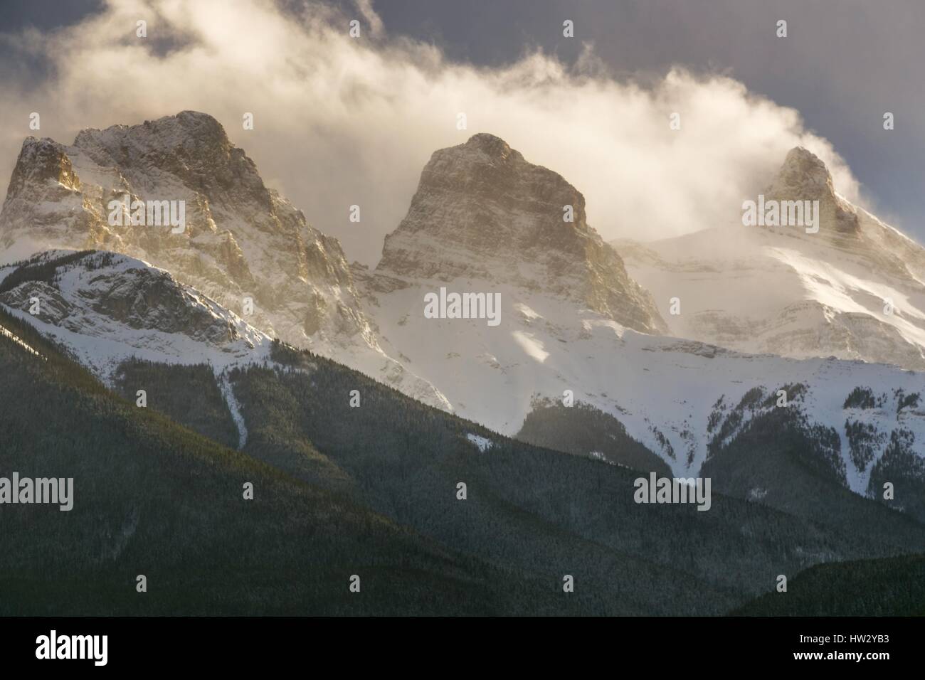 La neve copriva tre vette delle Sorelle sopra Canmore Alberta oscurate dalle nuvole. Bow Valley Winter Landscape Canadian Rockies Banff National Park Foto Stock