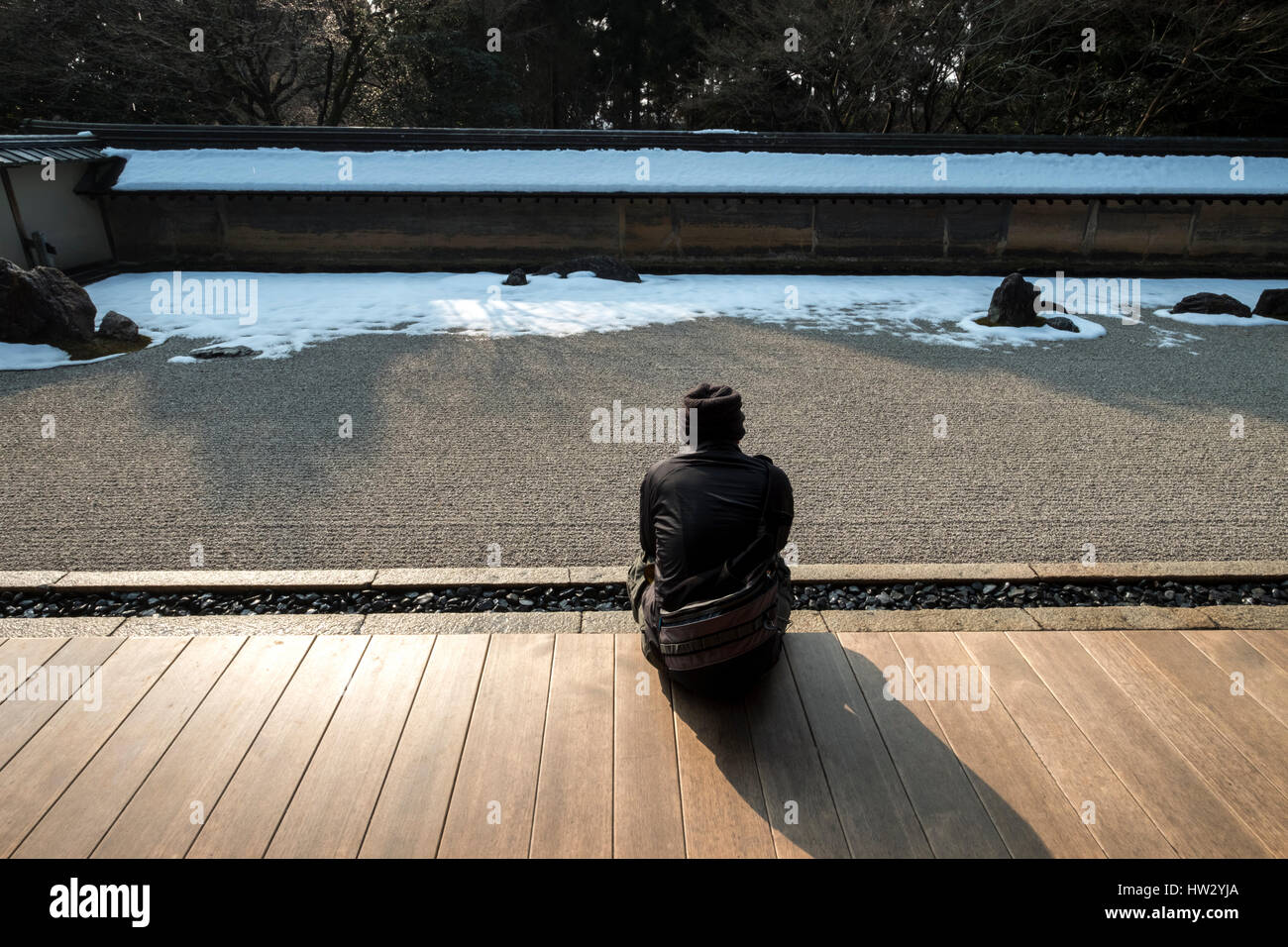 Un visitatore osserva Ryoan-ji il famoso giardino di roccia dall'edificio Hojo a Kyoto, Kansai, Giappone Foto Stock