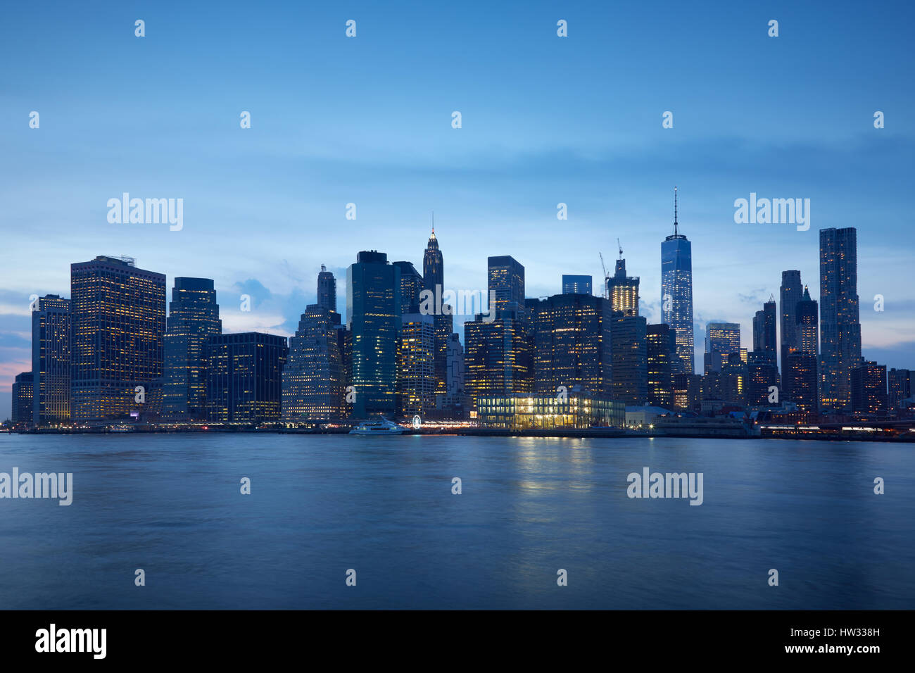 New York skyline della città con edifici illuminati in blu ore serali Foto Stock