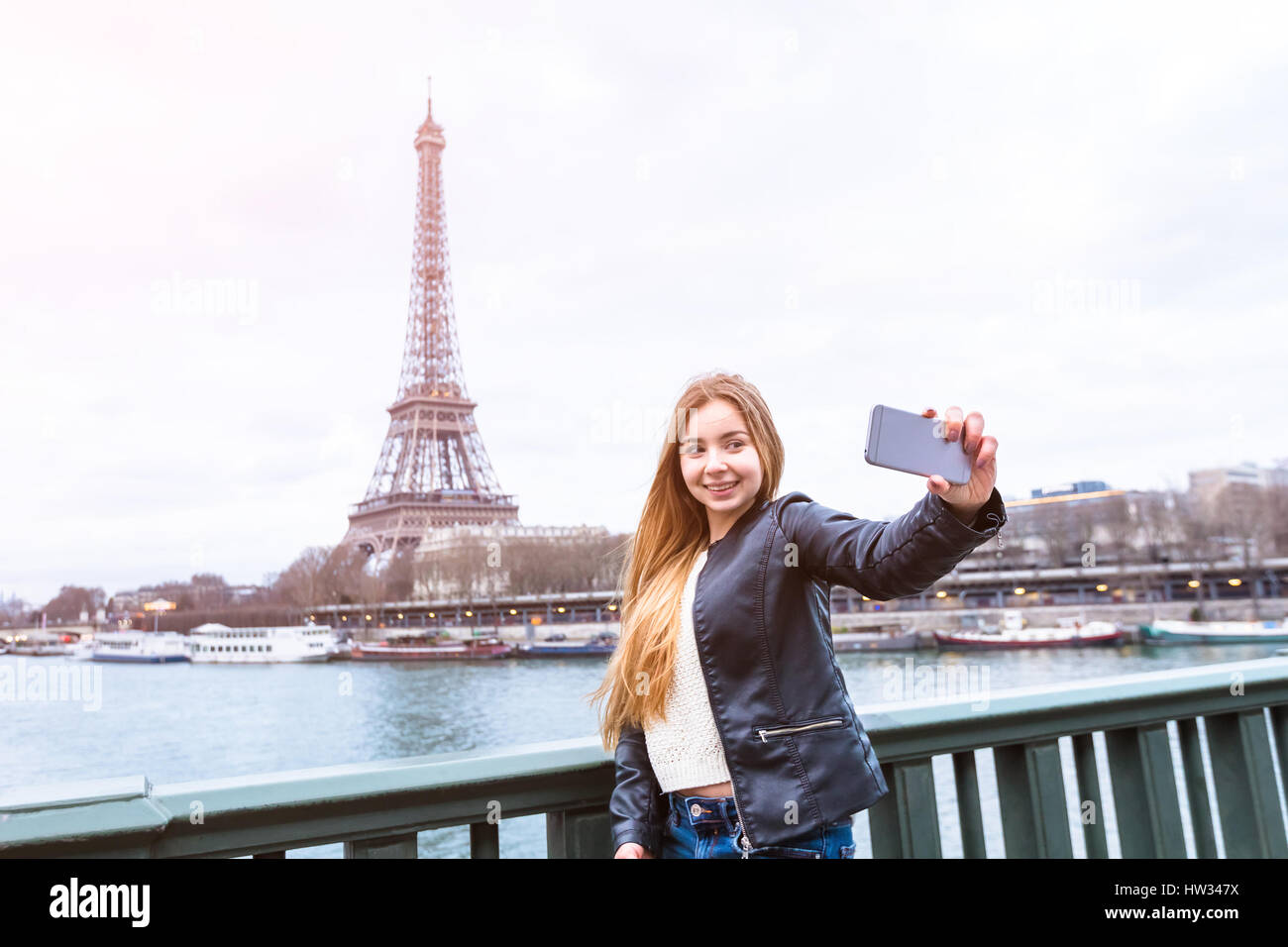 Bella ragazza turistica prendendo un selfie foto di se stessa di fronte alla Torre Eiffel a Parigi Foto Stock