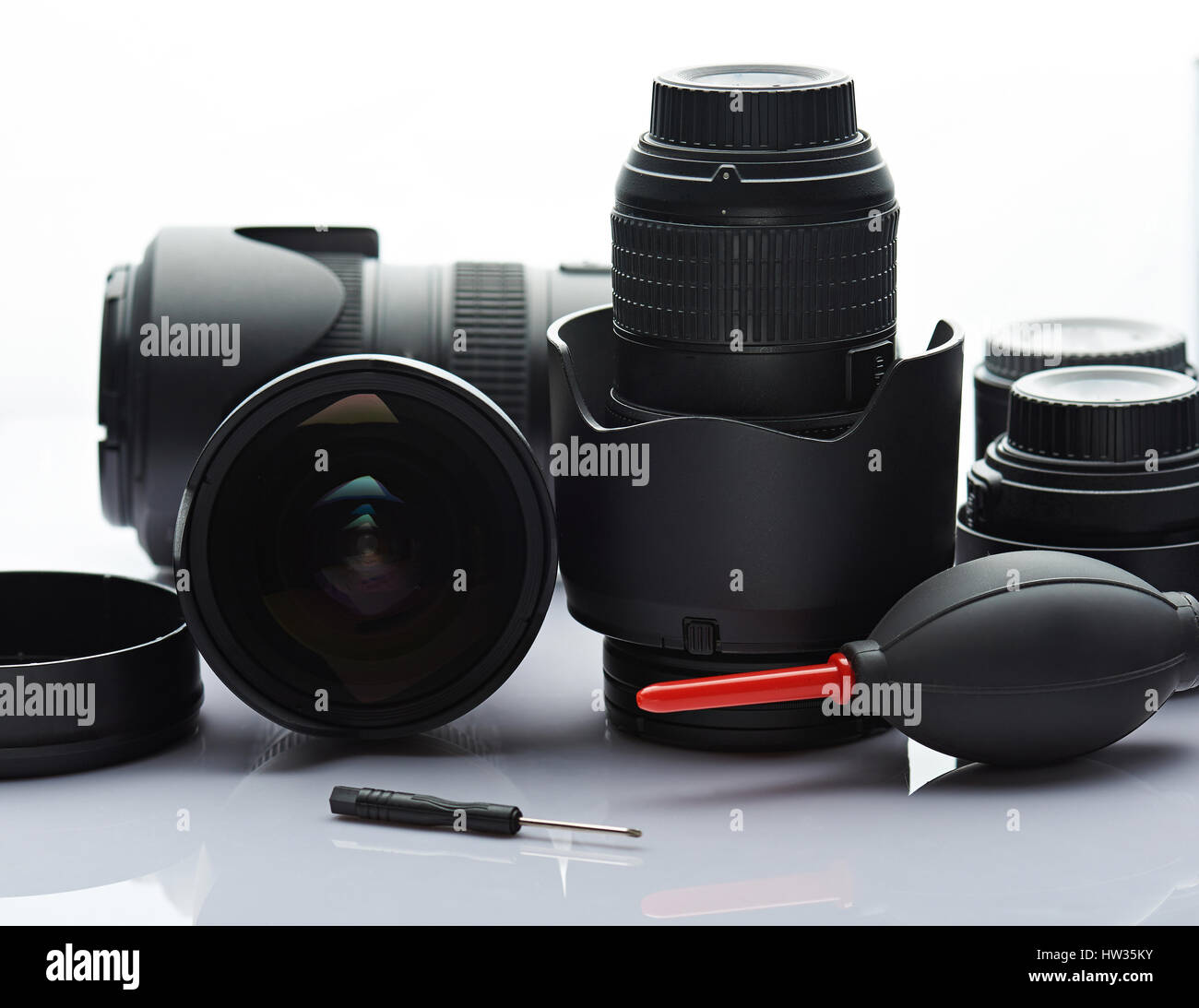 Pulire la lente della fotografia con strumenti isolati su sfondo bianco. Pulizia professionale servizio di ottica Foto Stock