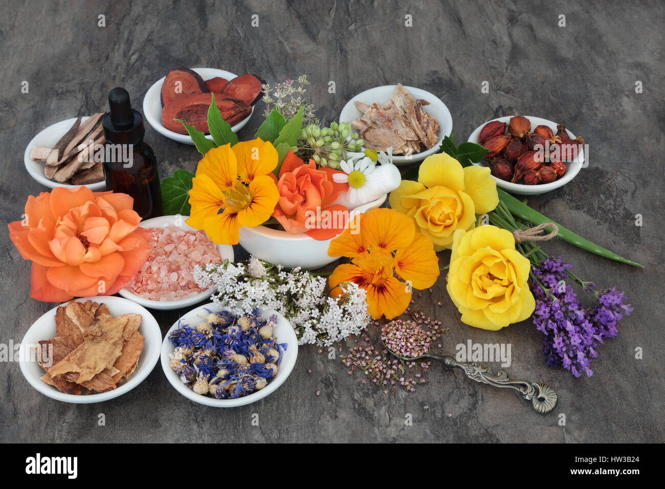 Fiore e selezione di erbe utilizzate in alternativa naturale a base di erbe con olio essenziale di biberon e mortaio con pestello. Foto Stock