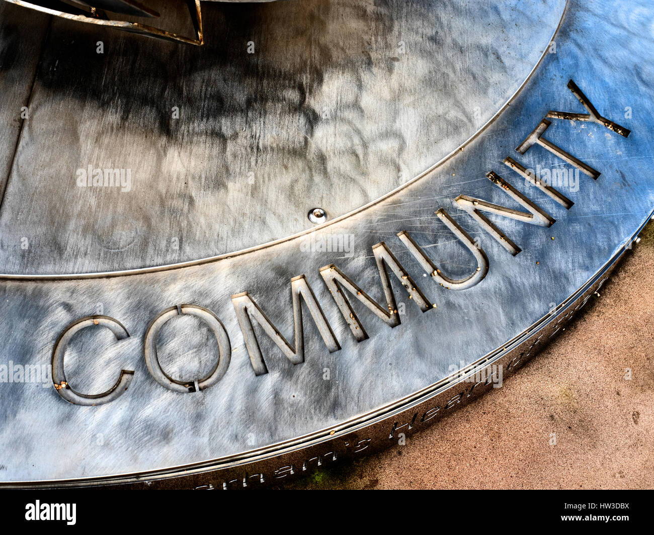 Iscrizione comunitario sul plinto di cuore di scultura in acciaio da Steve Mehdi in Minster Gardens Rotherham South Yorkshire Inghilterra Foto Stock
