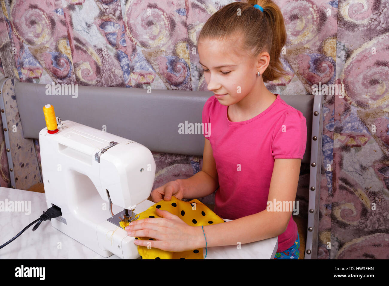Ragazza impara a cucire su un elettrico macchina da cucire Foto Stock
