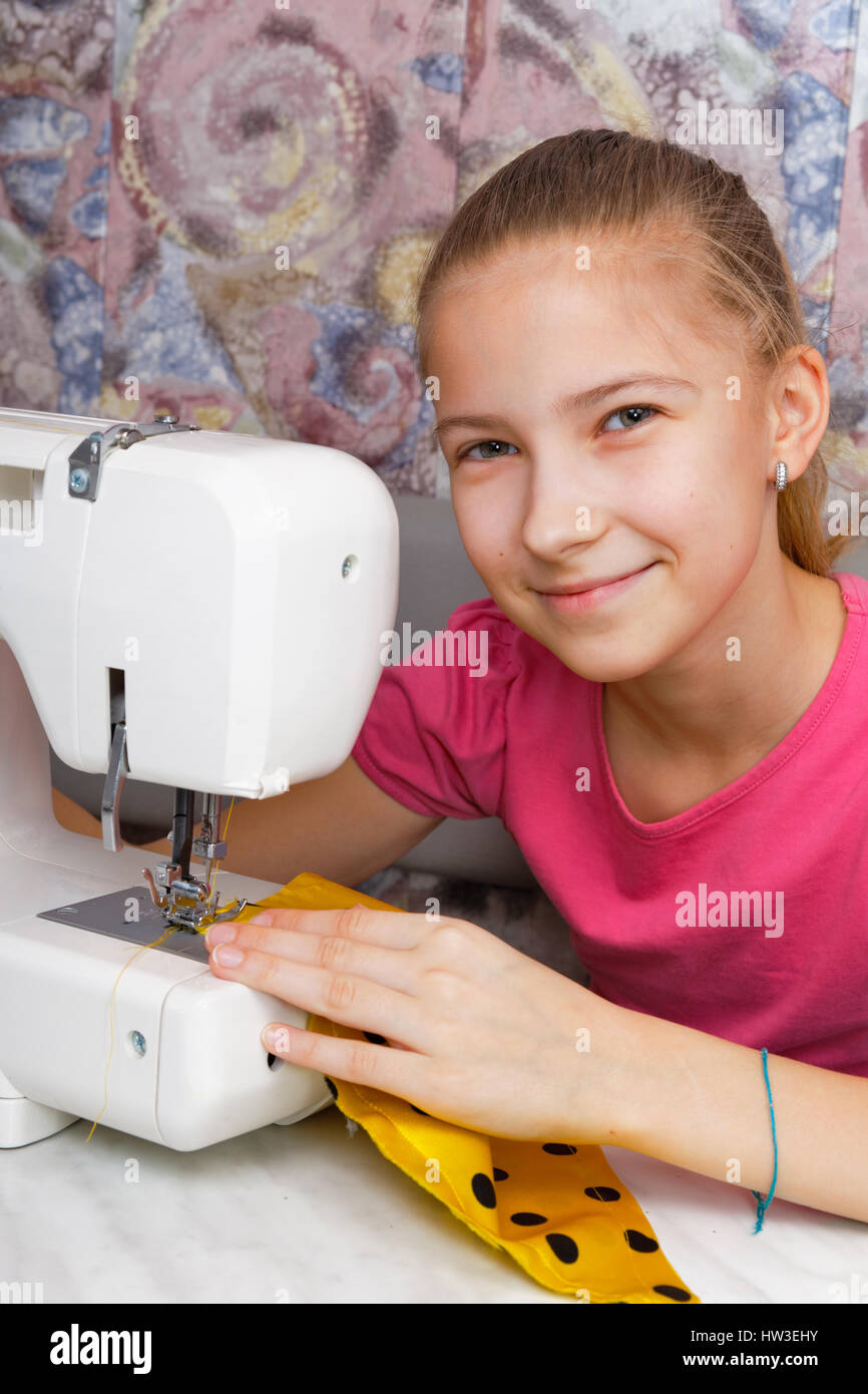 Ragazza impara a cucire su un elettrico macchina da cucire Foto Stock