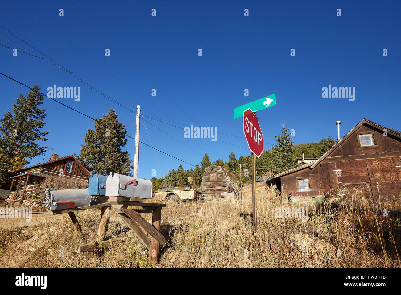 Vecchio caselle di posta e segno di stop in remoto villaggio, Colorado, Stati Uniti d'America. Foto Stock