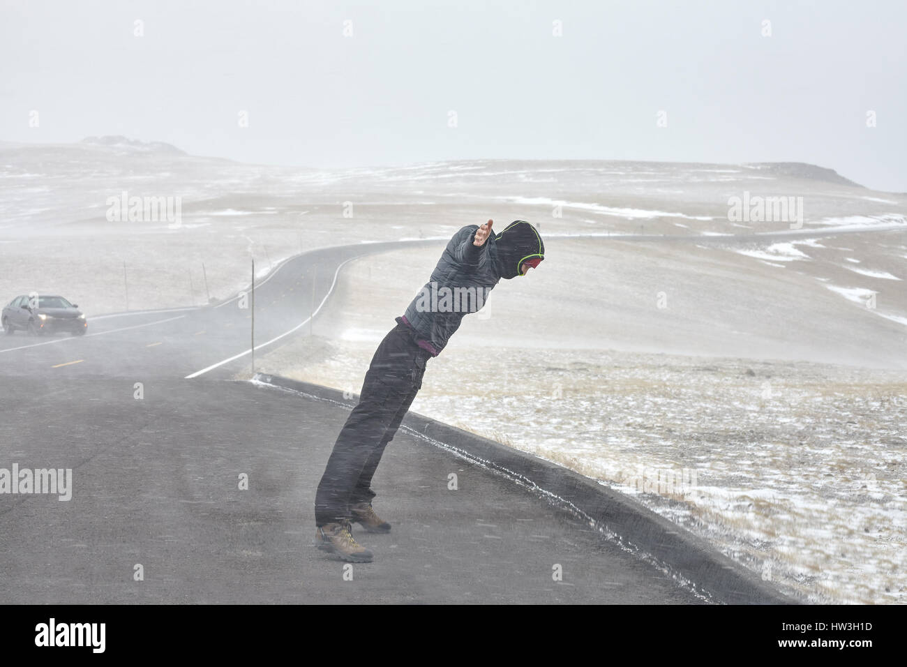 Donna cerca di stare in piedi contro la tempesta di neve, forza del concetto di natura. Foto Stock