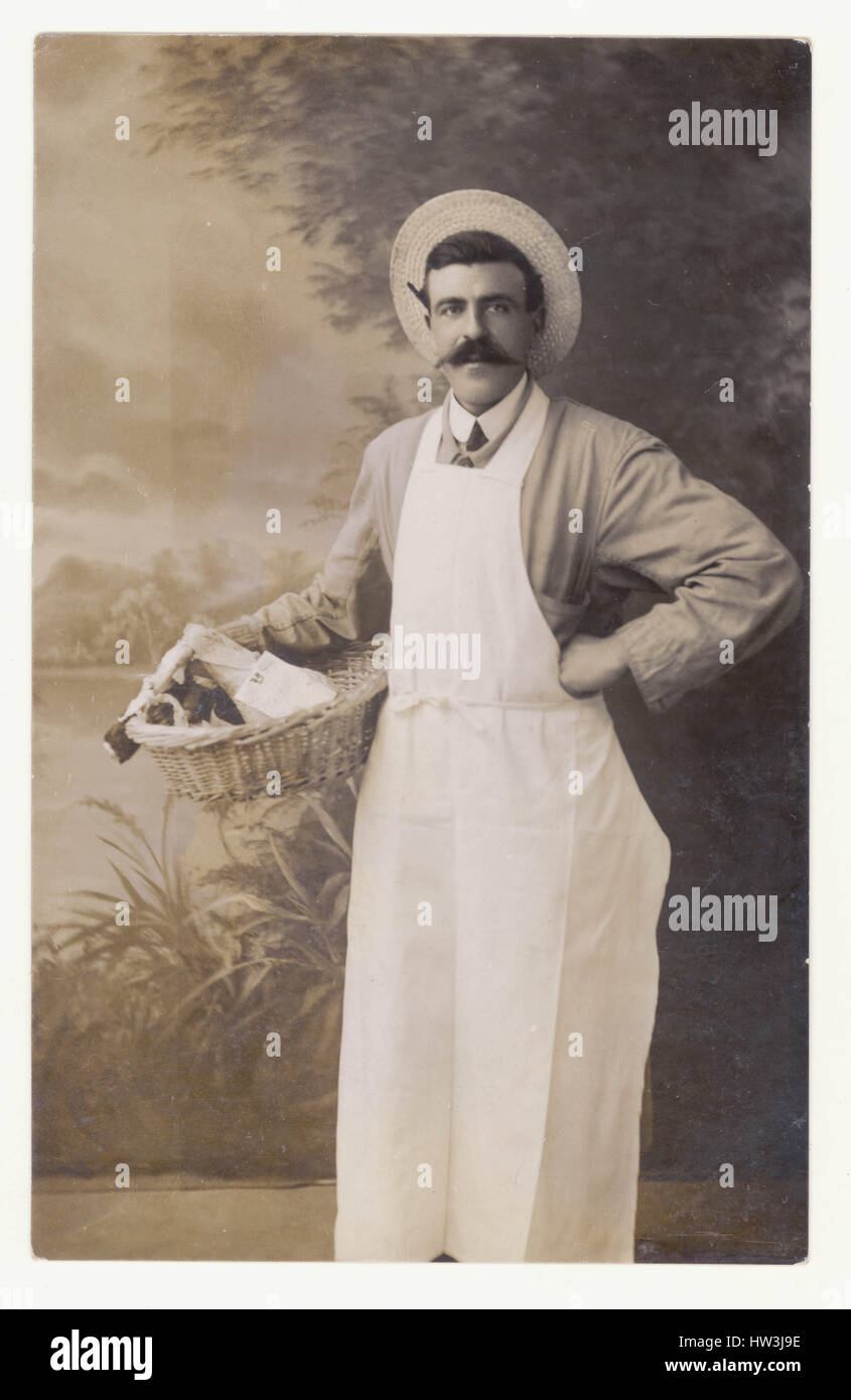 Edwardian cartolina di drogheria proprietario del negozio, personale o assistente, portando il suo cesto di generi alimentari, ritratto in studio, R.U. circa. 1910 Foto Stock