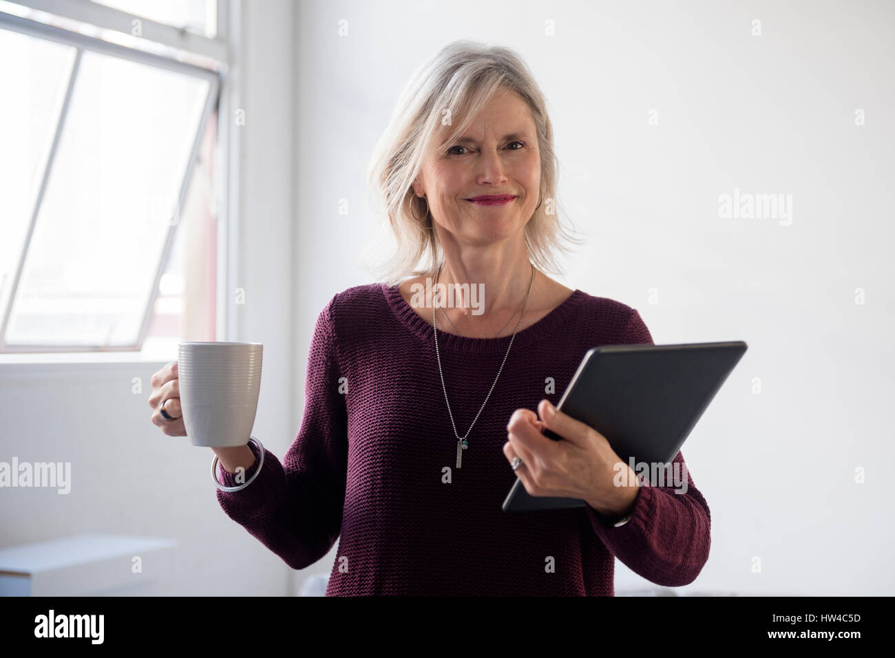 Ritratto di soggetti di razza caucasica imprenditrice azienda tazza di caffè e tavoletta digitale Foto Stock