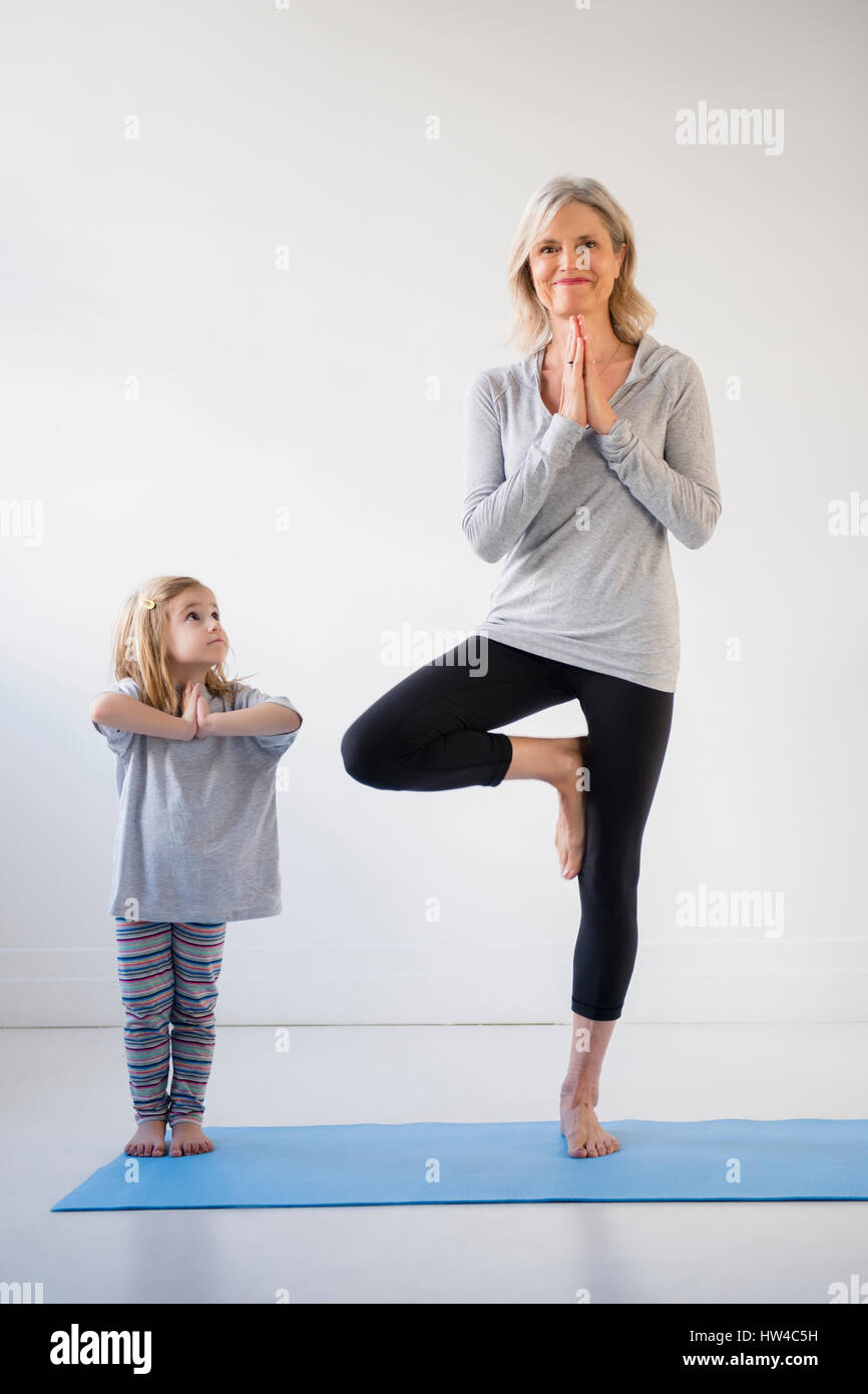 Nipote caucasica Guarda la nonna a praticare yoga Foto Stock