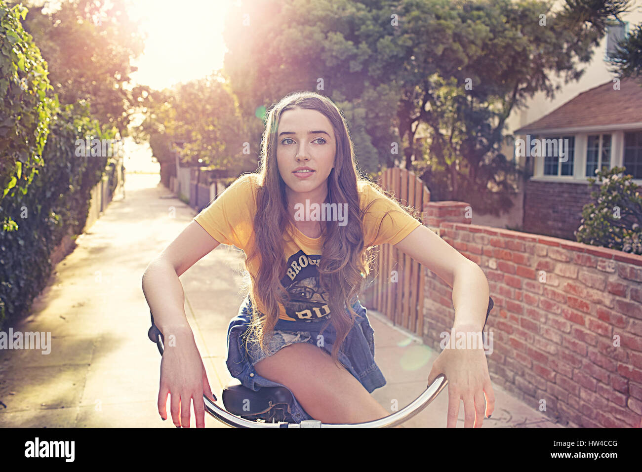 La donna caucasica Bicicletta Equitazione in vicolo Foto Stock