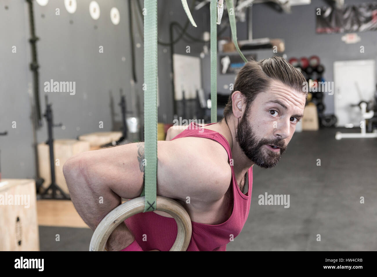 Razza mista uomo che lavora fuori con anelli in palestra Foto Stock