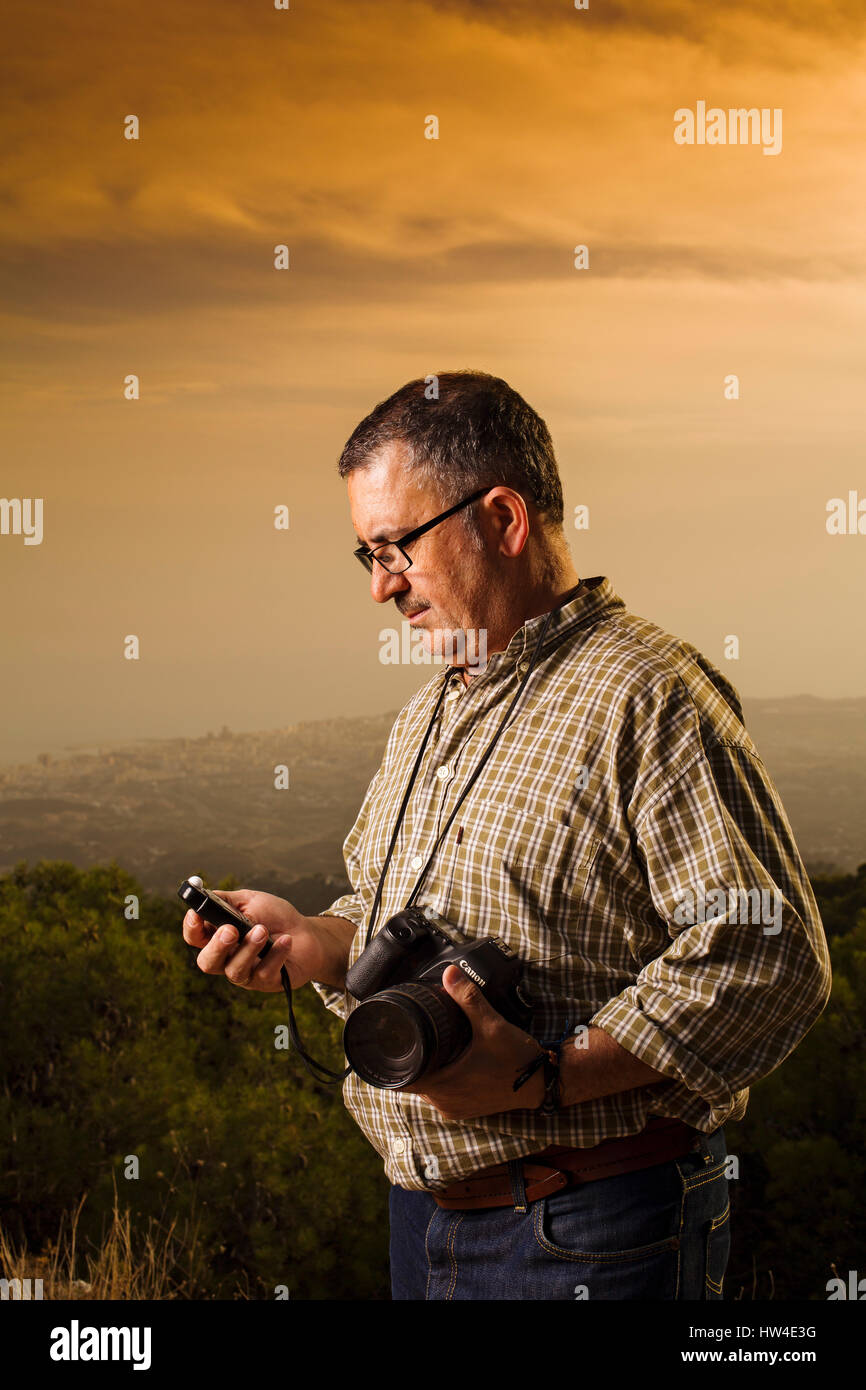 Assistente fotografo misurando la luce in una foto riprese in esterni al tramonto Foto Stock