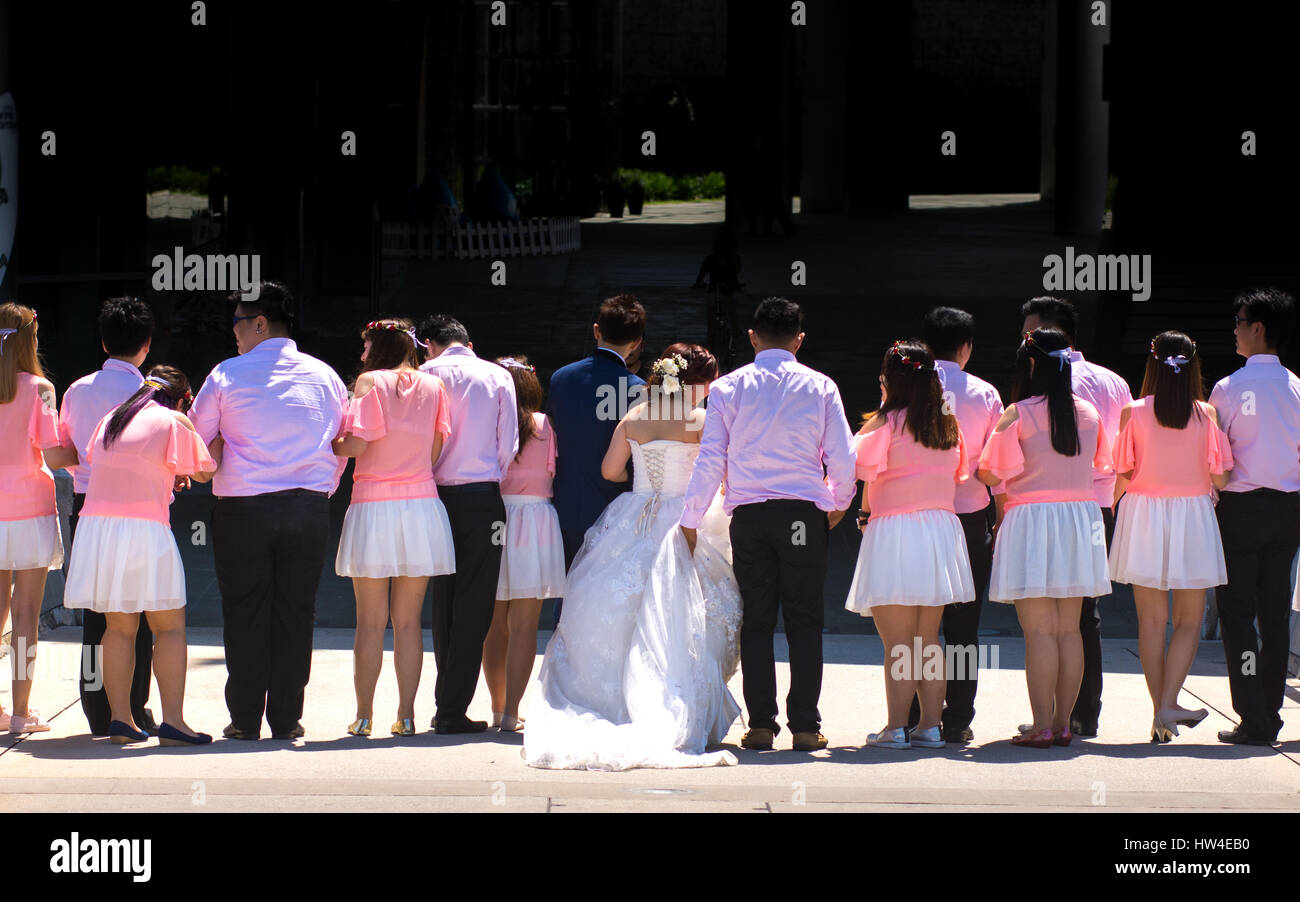Sposa e lo sposo più grande gruppo di ospiti di nozze avente una foto scatta durante una giornata di sole. Foto Stock