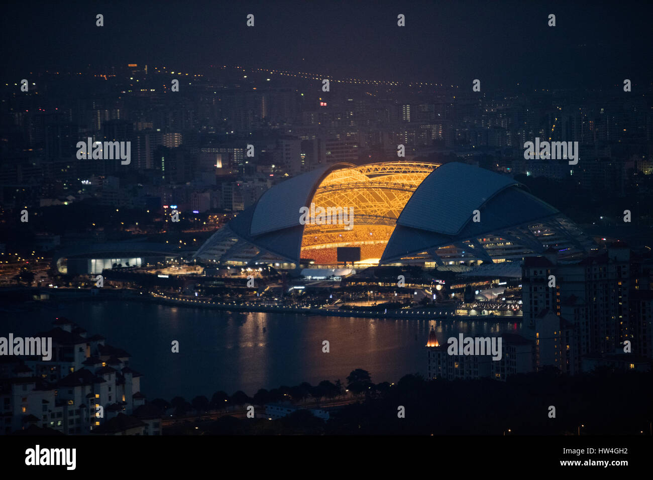 Vista esterna del Singapore Sport mozzo in corrispondenza di notte. Foto Stock
