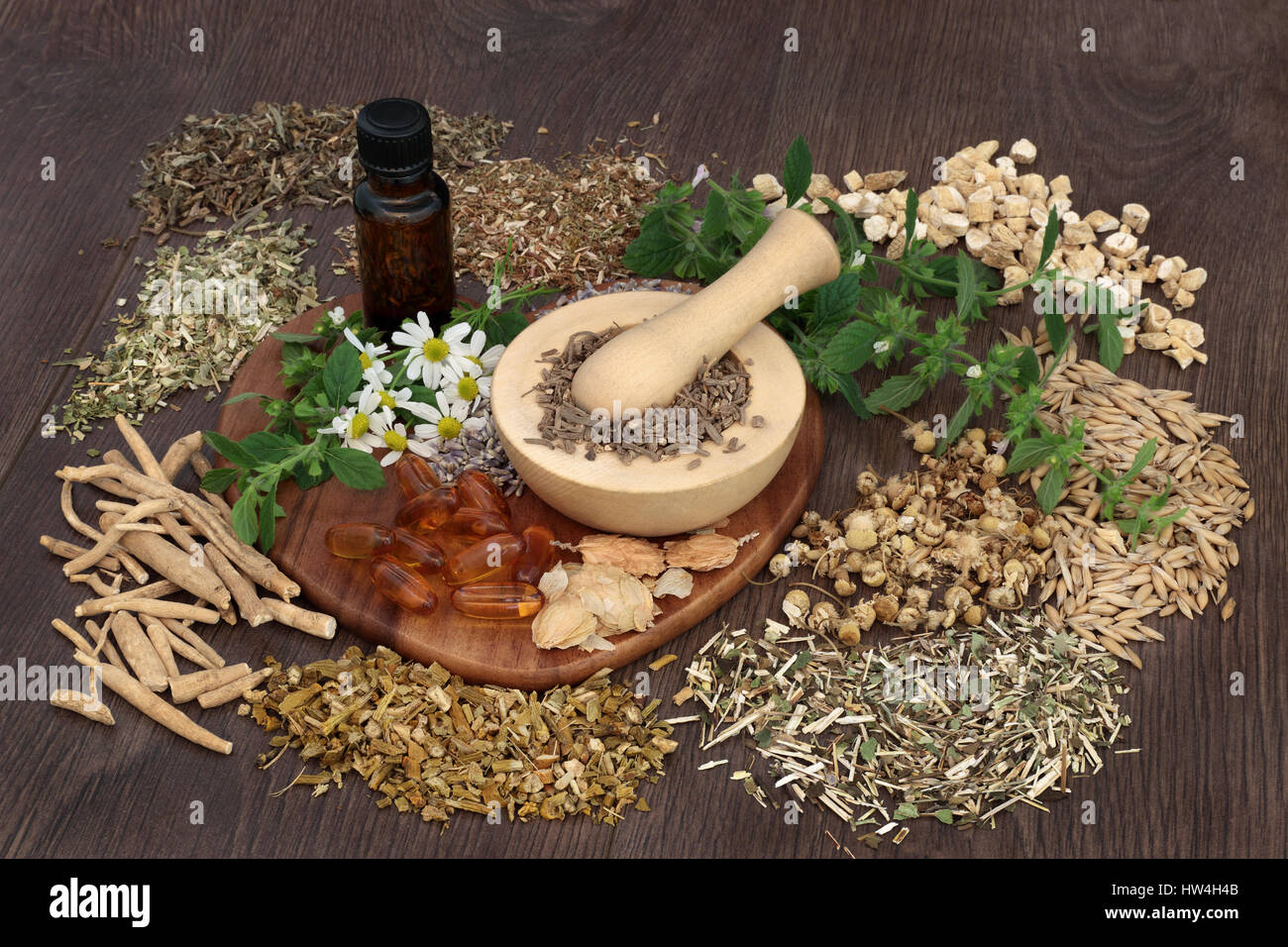A base di erbe naturali farmaci utilizzati per curare ansia e disturbi del sonno con mortaio e pestello e olio essenziale bottiglia su sfondo di quercia. Foto Stock