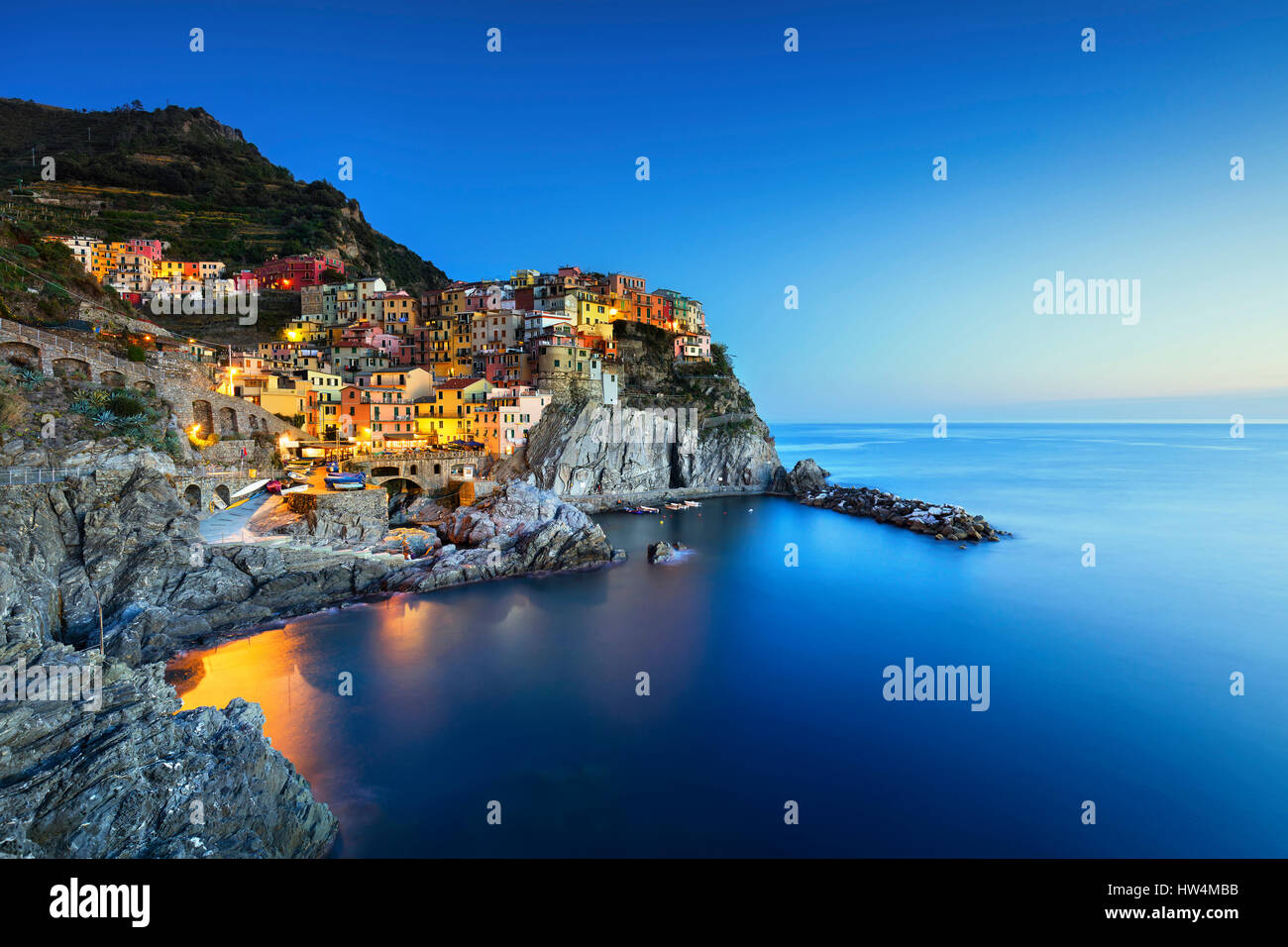 Manarola village sulla scogliera di rocce e mare al tramonto., Seascape in cinque terre, il Parco Nazionale delle Cinque Terre Liguria Italia Europa. Esposizione lunga Foto Stock