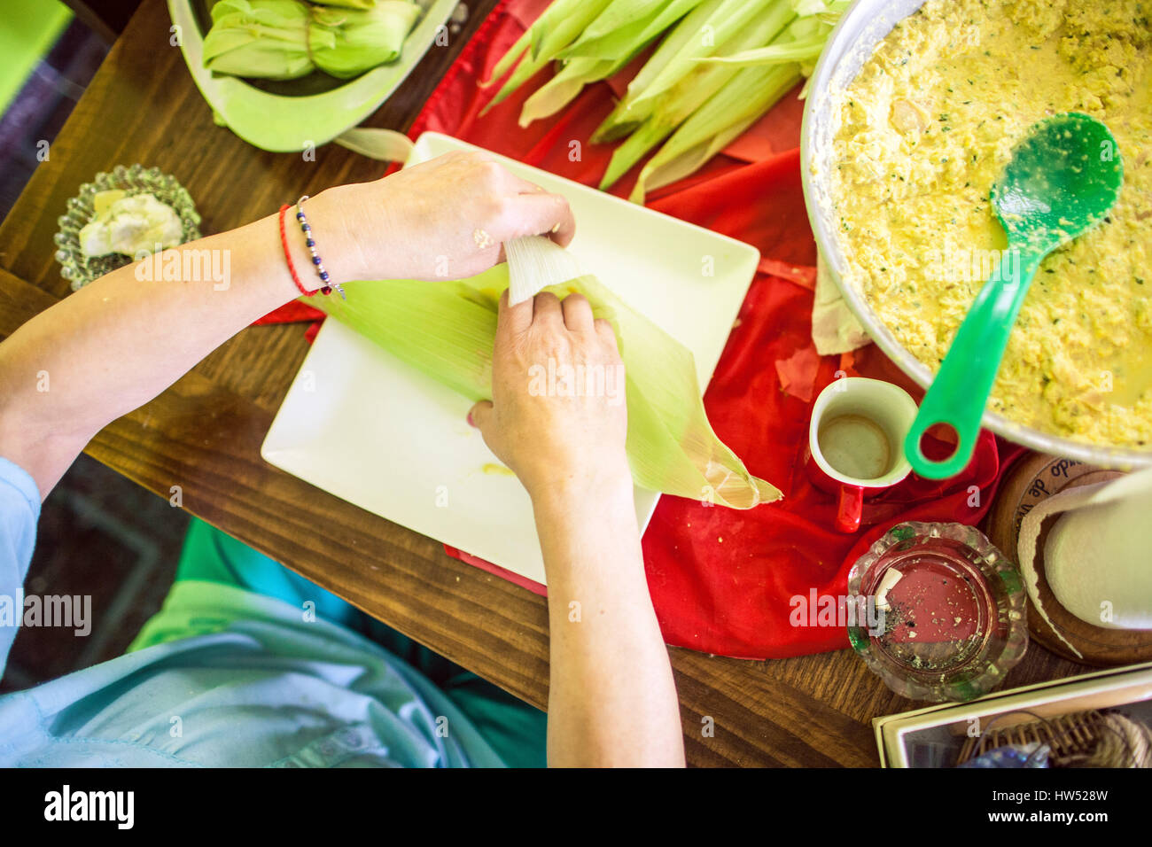 Una donna che prepara un piatto Mesoamerican chiamato "Tamales". Si tratta di un piatto fatto di masa che è avvolto in Corn buccia e deve essere cotto a vapore. Foto Stock