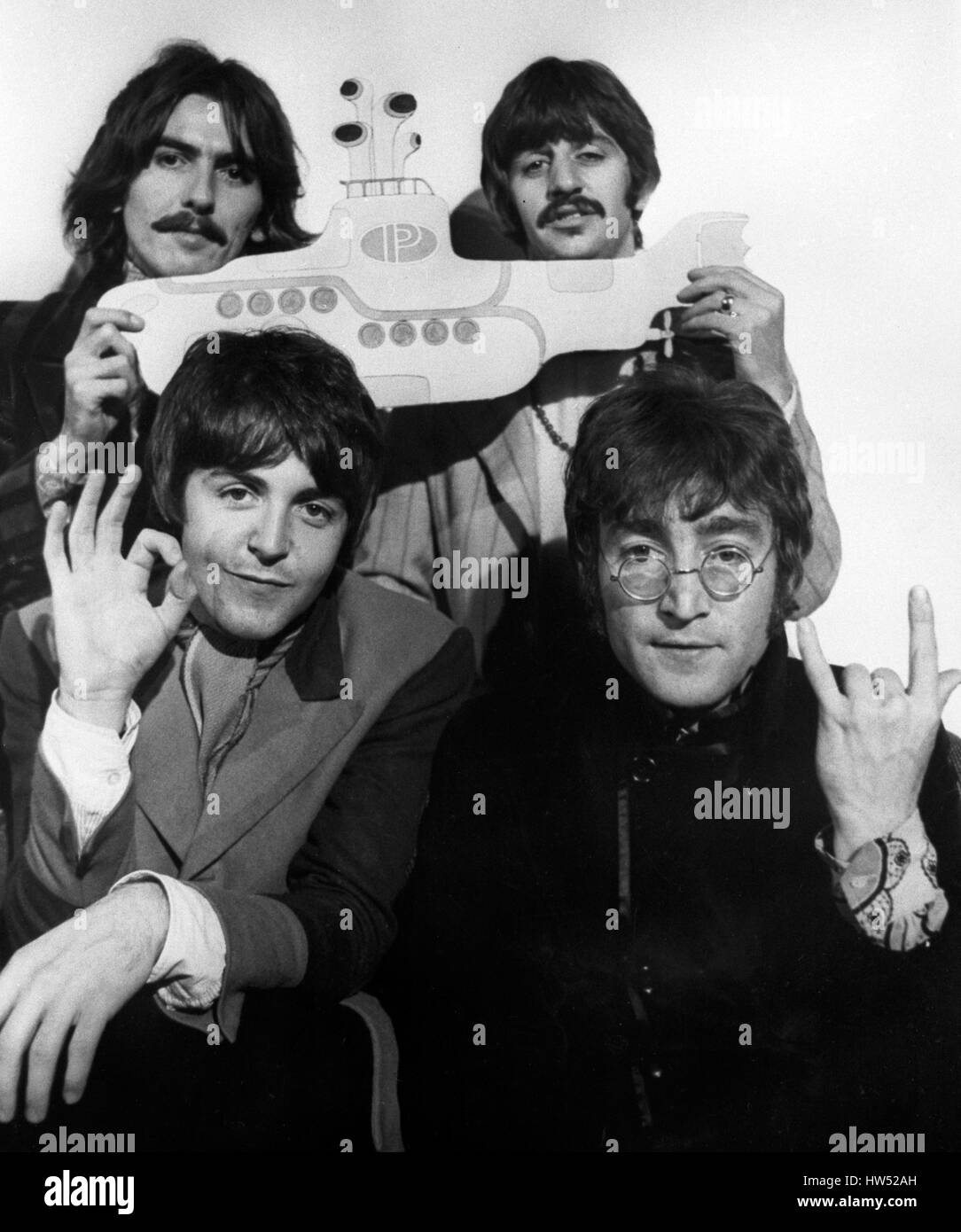 I Beatles, George Harrison e Ringo Starr (sfondo l-r) e Paul McCartney e John Lennon (anteriore l-r) con un ritaglio di un sottomarino giallo, pubblicizzando il gruppo animate di full-length lungometraggio ora in produzione a Londra per il rilascio da parte di United Artists. Foto Stock