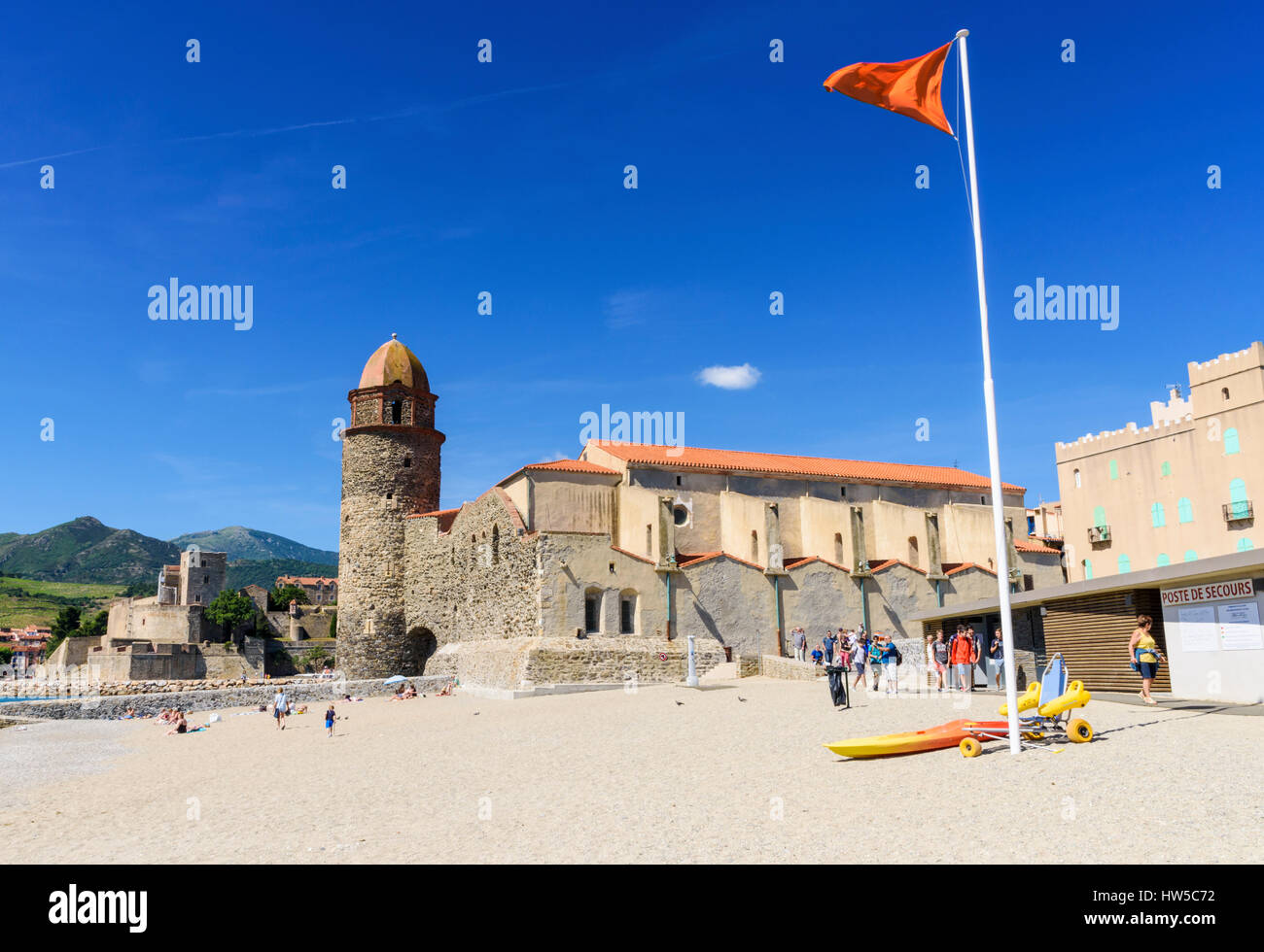 Spia arancione indicatore su St Vincent Beach - la balneazione pericolosi ma guardati - dominata dalla Cattedrale di Notre Dame des Anges, Collioure, Côte Vermeille, Francia Foto Stock