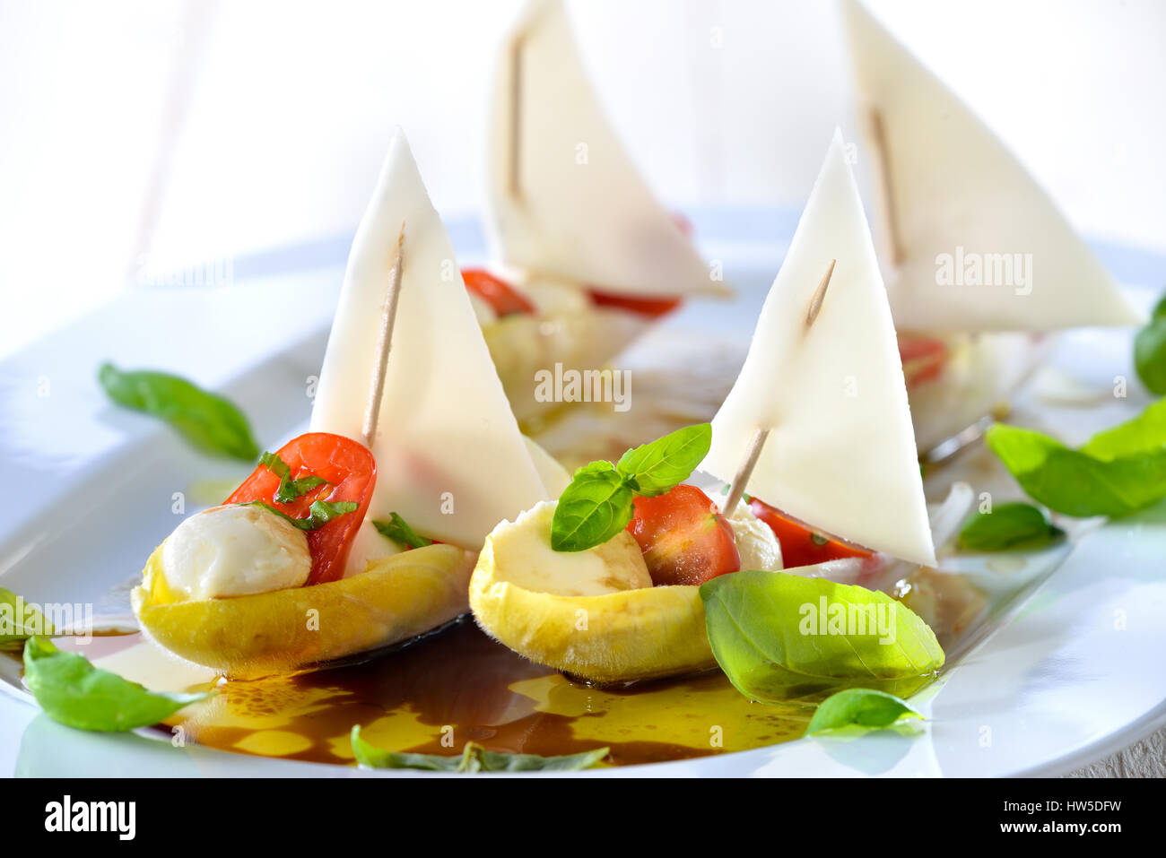Foglie di cicoria farcita con pomodorini e mozzarella sfere, conditi con olio di oliva e aceto balsamico Foto Stock