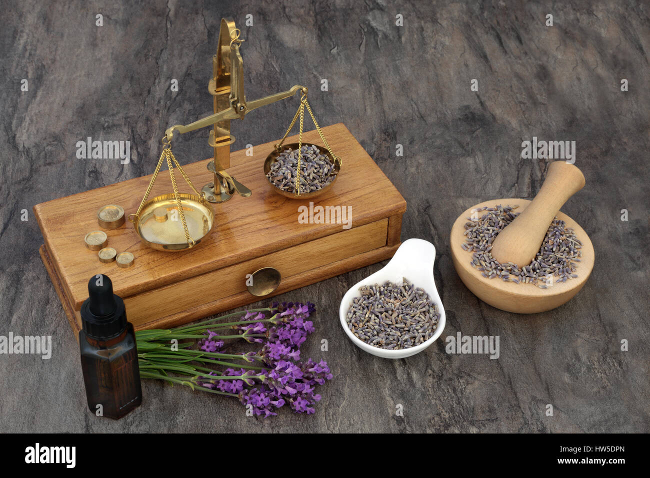 Lavanda fiori di erbe utilizzate in alternativa naturale della medicina con le vecchie scale di ottone, aromaterapia olio essenziale bottiglia e mortaio con pestello. Foto Stock