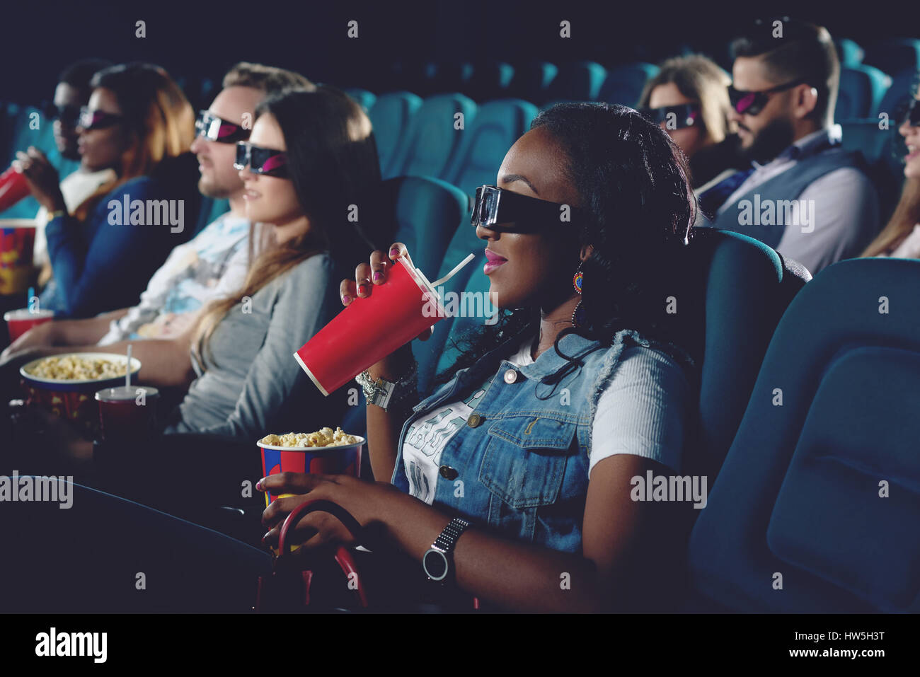 Ragazza africana di bere cola e guardare film in 3d. Foto Stock