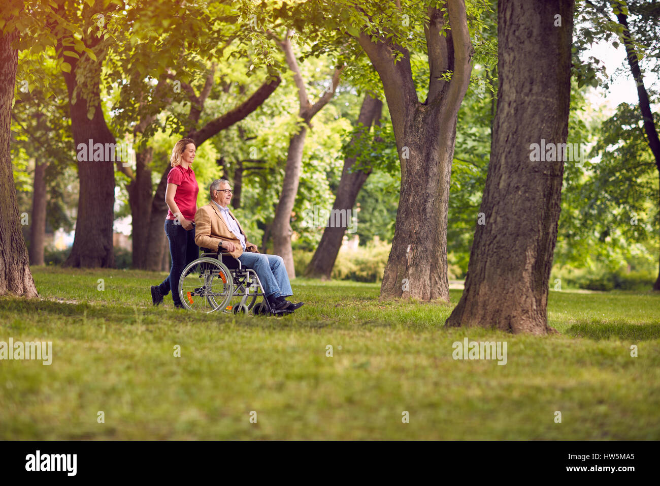 La famiglia felice tempo- godendo senior uomo in sedia a rotelle e la figlia nel parco Foto Stock