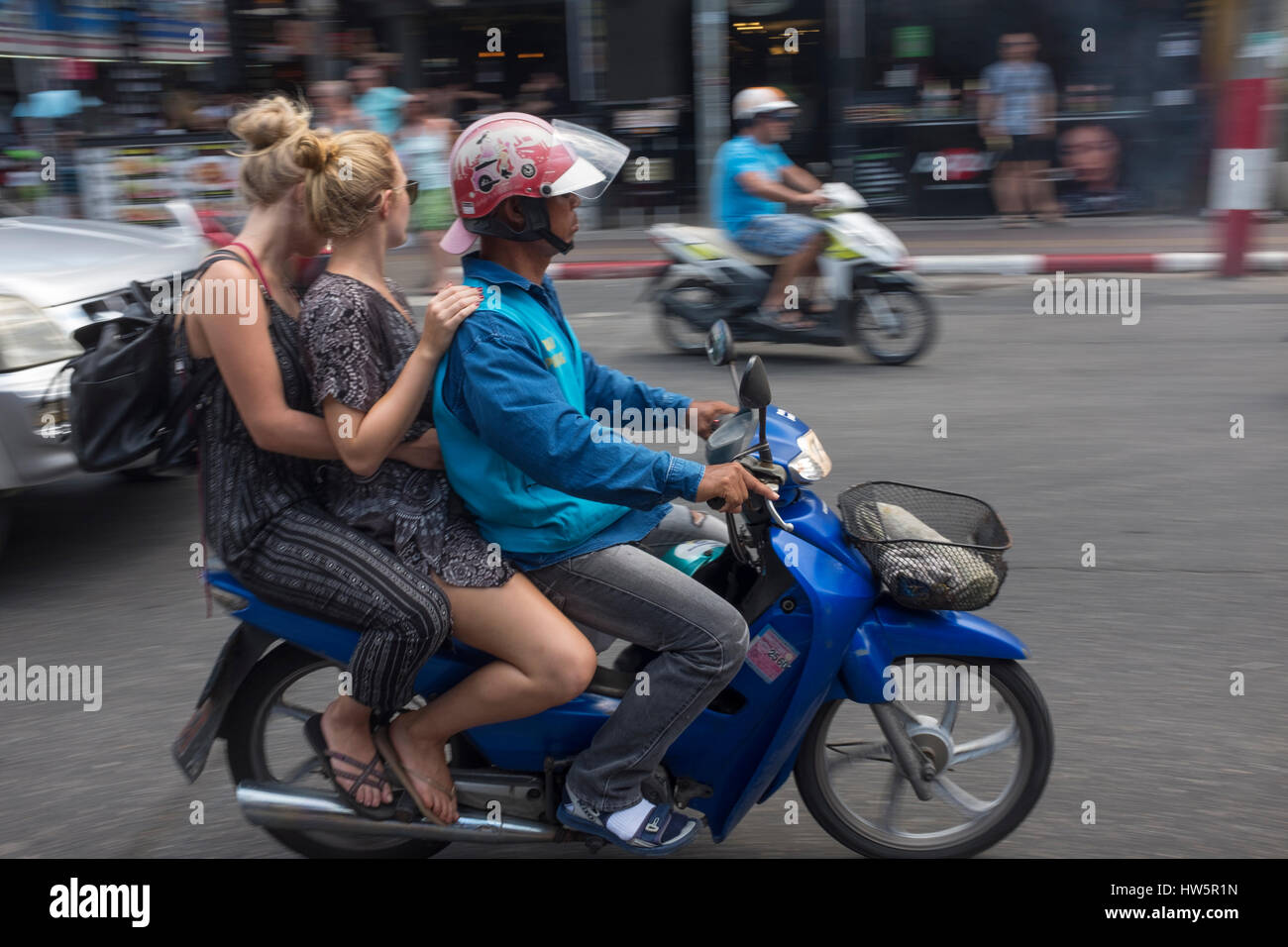 Un uomo tailandese il motociclismo con due turisti occidentali a Phuket, Tailandia. 04-Mar-2017 Foto Stock