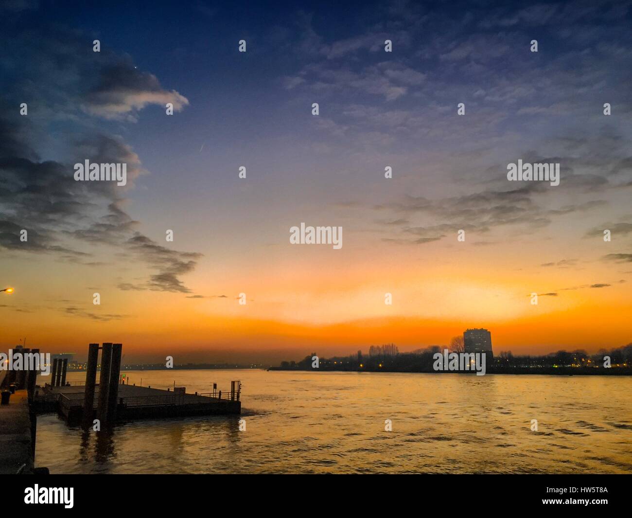 Drammatica e colorato tramonto riflesso nell'acqua del fiume Scheld ad Anversa, Belgio, Europa Foto Stock