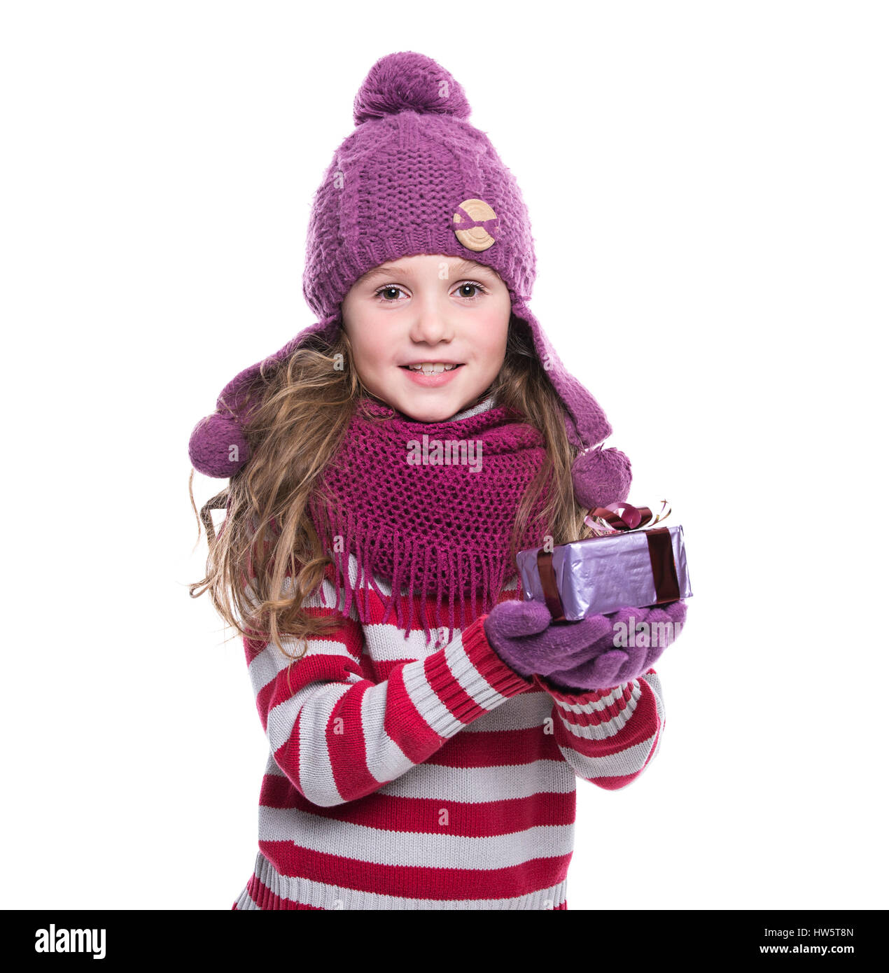 Carino sorridente bambina indossa viola sciarpa lavorata a maglia, guanti e  cappello, tenendo regalo di Natale isolato su sfondo bianco. Abbigliamento  invernale e christm Foto stock - Alamy