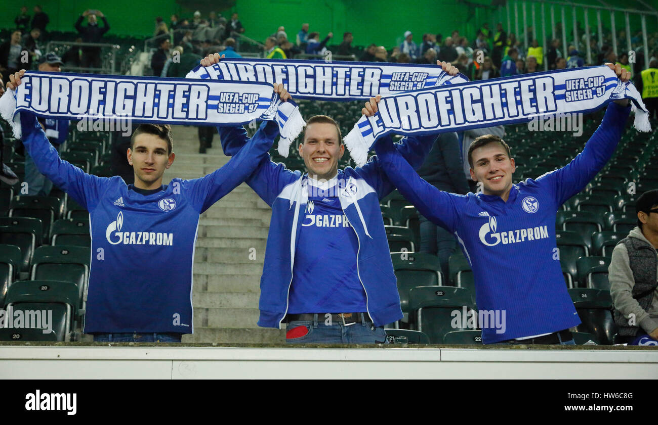 Sport calcio UEFA Europa League, 2016/2017, Round di 16, ritorno, Borussia Moenchengladbach vs FC Schalke 04 2:2, Stadio Borussia Park, visitatori spettatori appassionati di calcio di Schalke tenere sciarpe con l'etichetta Eurofighter Coppa UEFA vincitore 1997 Foto Stock