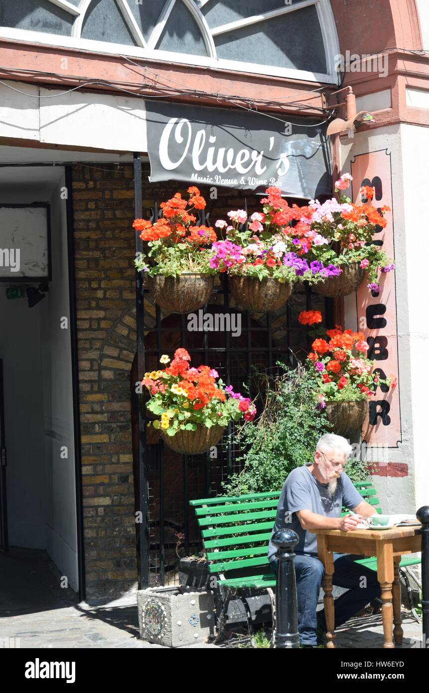 GREENWICH LONDRA 25 GIUGNO 2015: uomo fuori rilassante bar fiorita Foto Stock