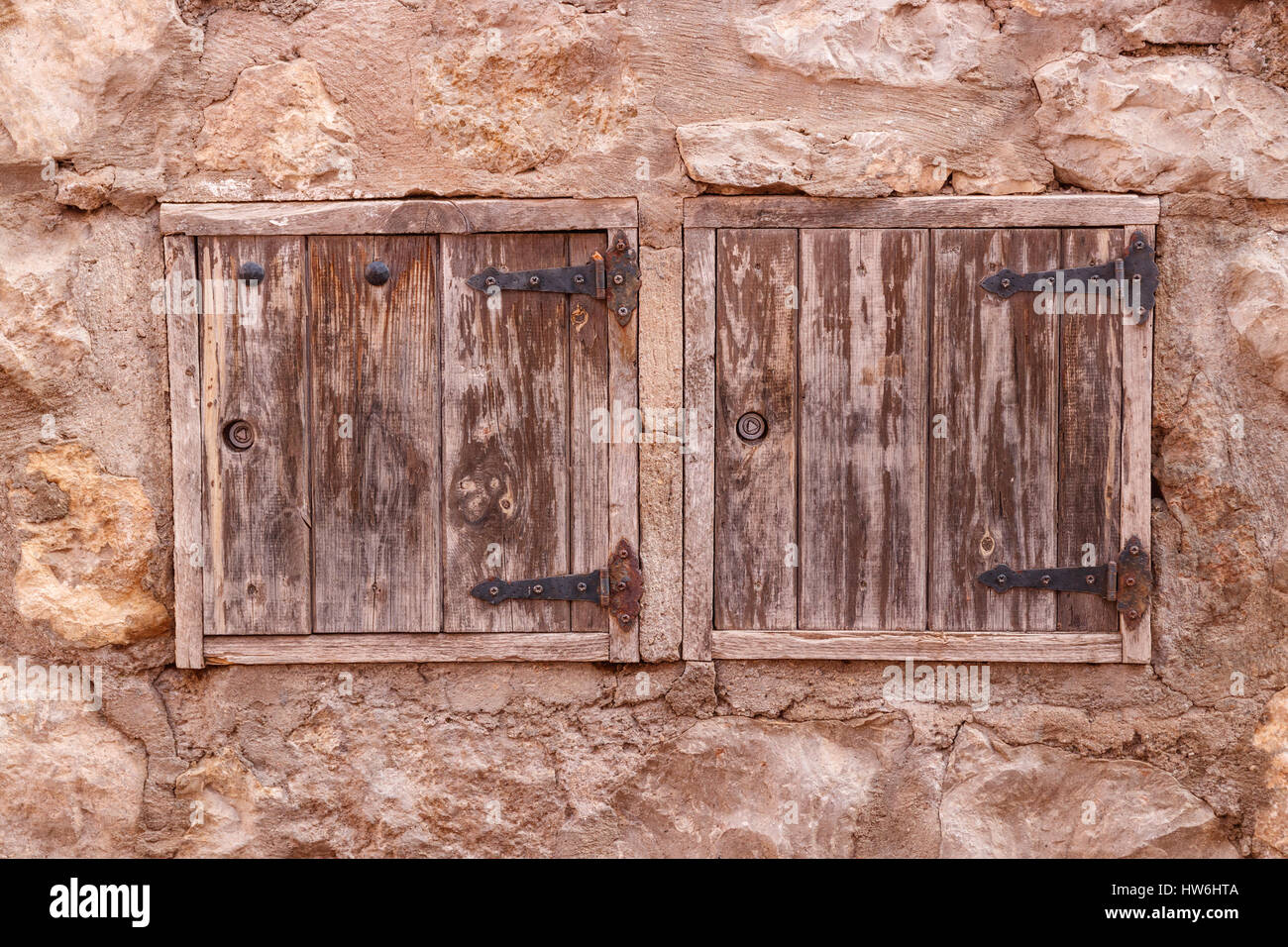 Due portelli di legno in un antico muro di pietra. Albarracin, Spagna. Foto Stock