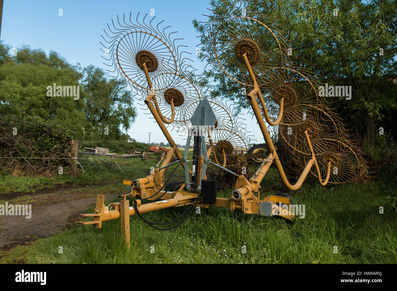 Otto ruote rastrello fieno in attesa di essere utilizzati in estate. Foto Stock