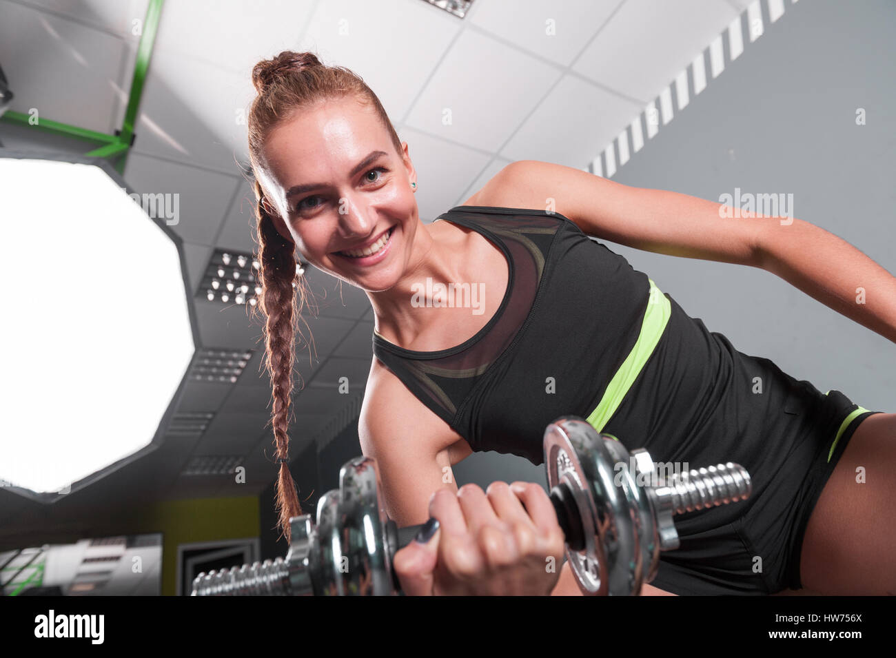Giovane donna fiducioso facendo bicipite esercizio curl con manubri nel  centro fitness. Slim girl allenamenti in palestra Foto stock - Alamy