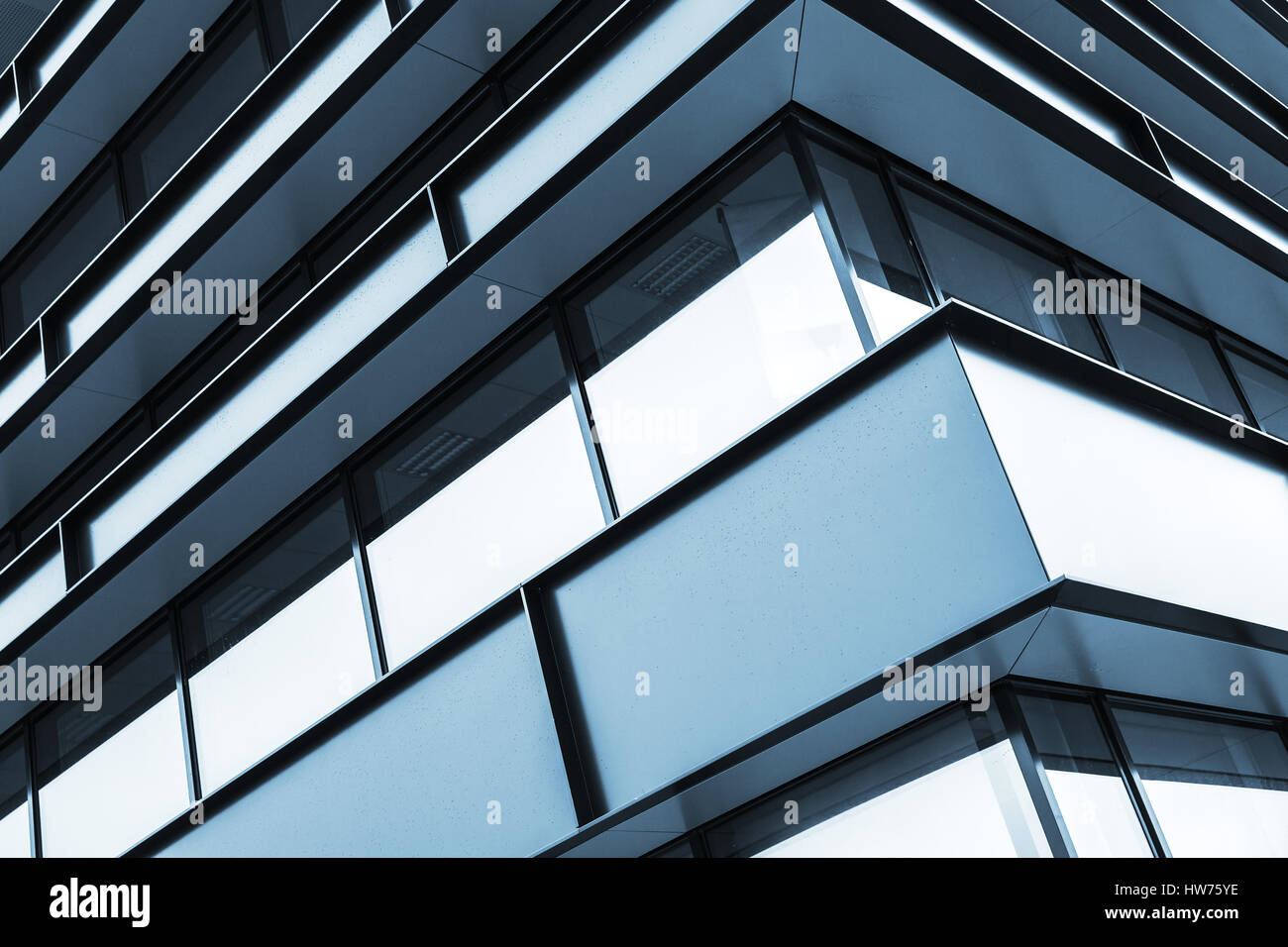 Moderno edificio industriale facciata frammento astratto e lucente di Windows nella struttura in acciaio, nei toni del blu dello sfondo della foto Foto Stock