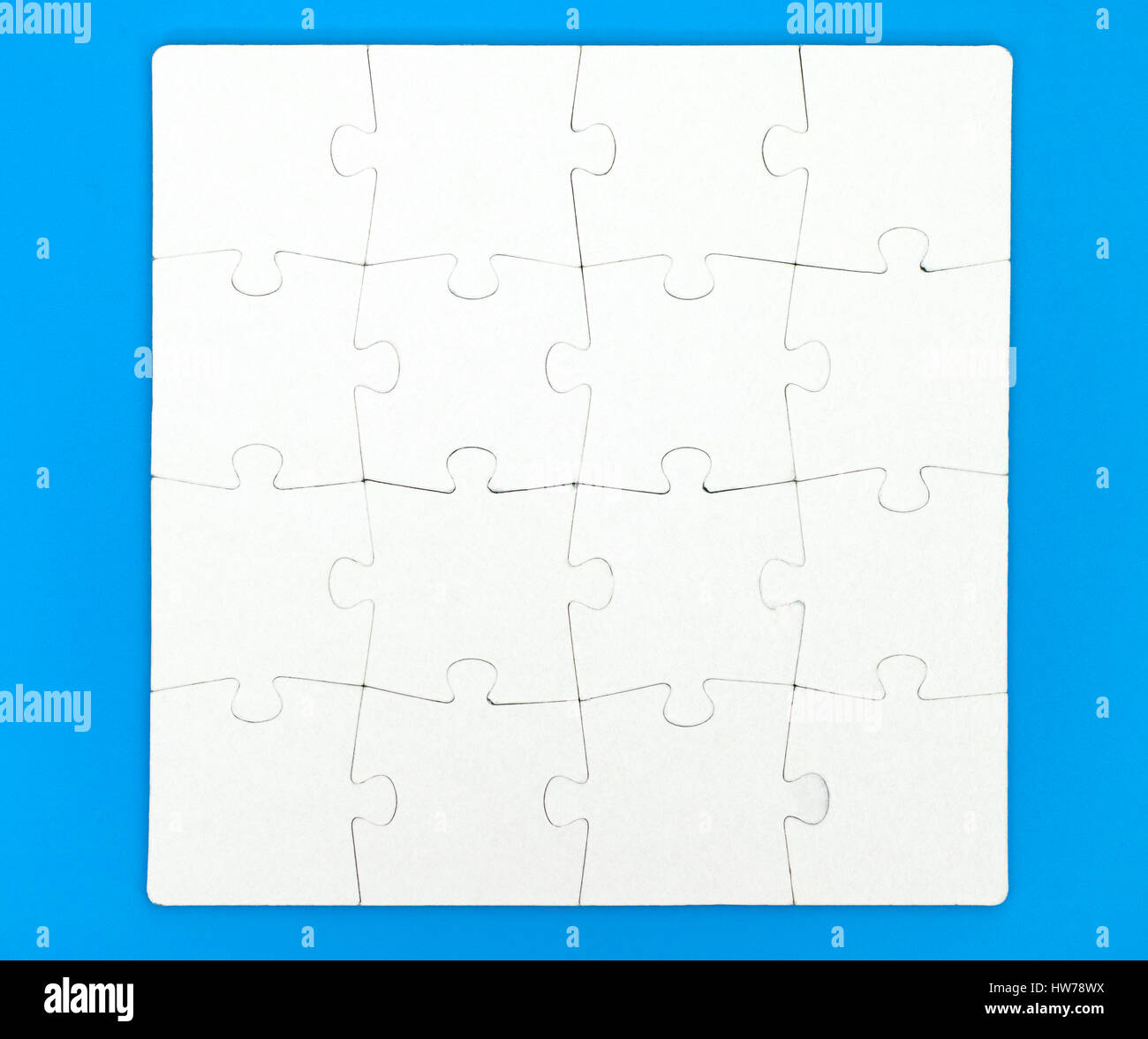 Puzzle di bianco con sedici pezzi su sfondo blu. Close-up. Foto Stock